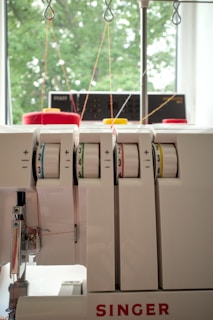 Close-up of a white singer serger sewing machine.