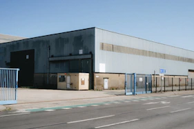 Large industrial warehouse with blue gates and road