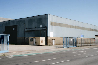 Large industrial warehouse with blue gates and road
