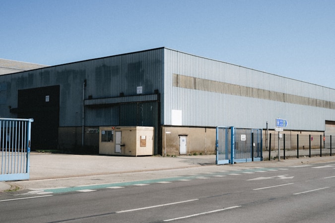 Large industrial warehouse with loading gates and an access road, similar to new North Las Vegas and Apex distribution centers