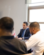 Two men in suits meeting with two other men.