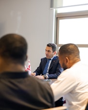 Two men in suits meeting with two other men.