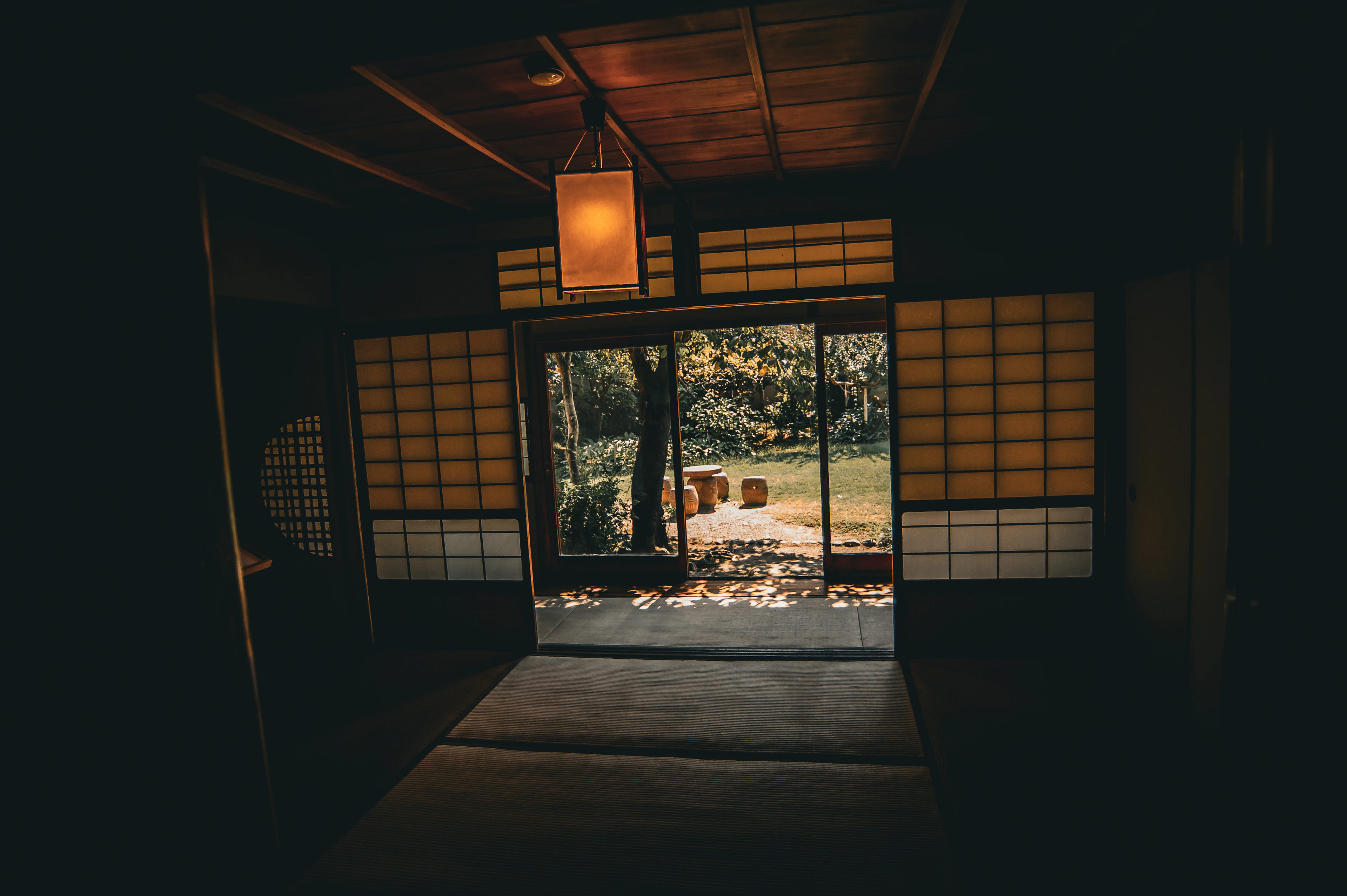 A traditional Japanese room with shoji screens, opening onto a garden