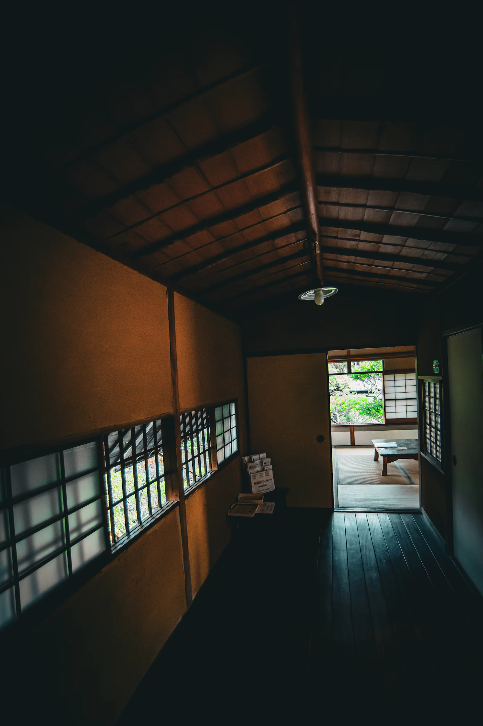 A dim wooden hallway lined with paper shoji screens.