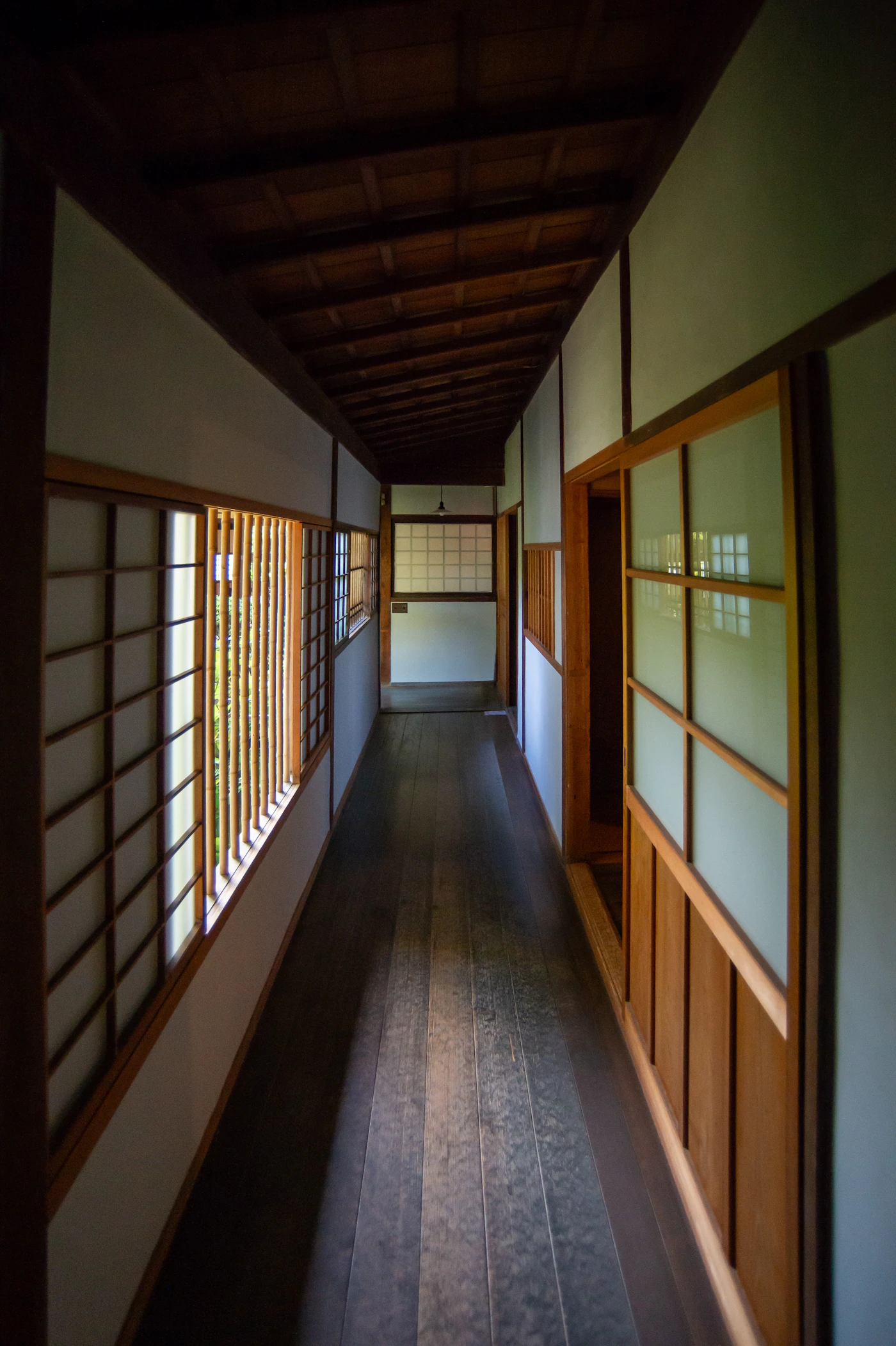 Long wooden hallway with traditional Japanese shoji screens, light from above