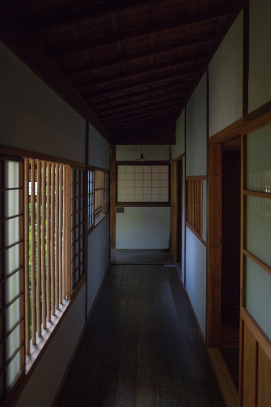Traditional Japanese hallway with wooden lattice windows showing preserved architectural character