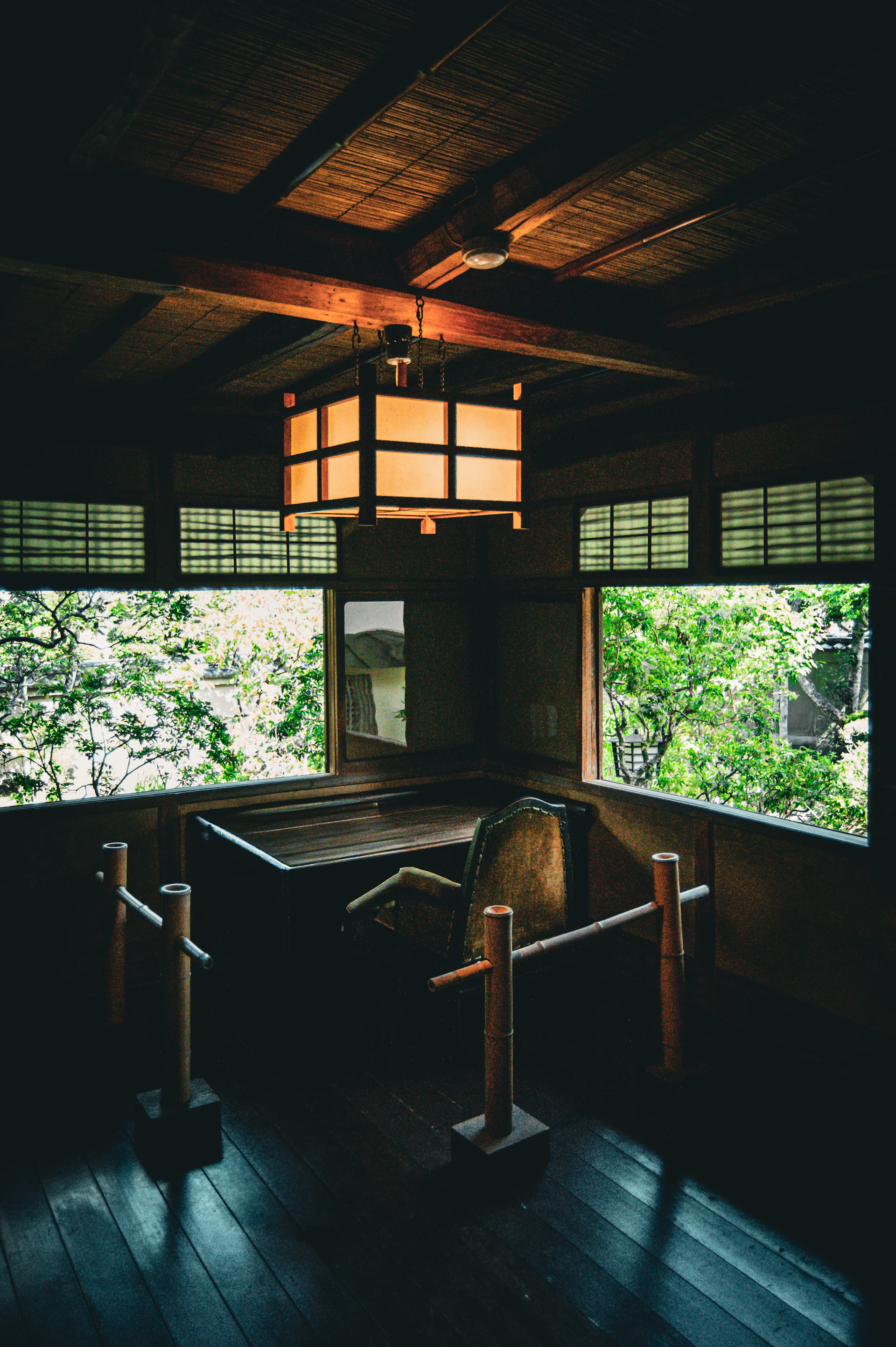 Traditional Japanese room with a hanging paper lantern, low desk and garden view