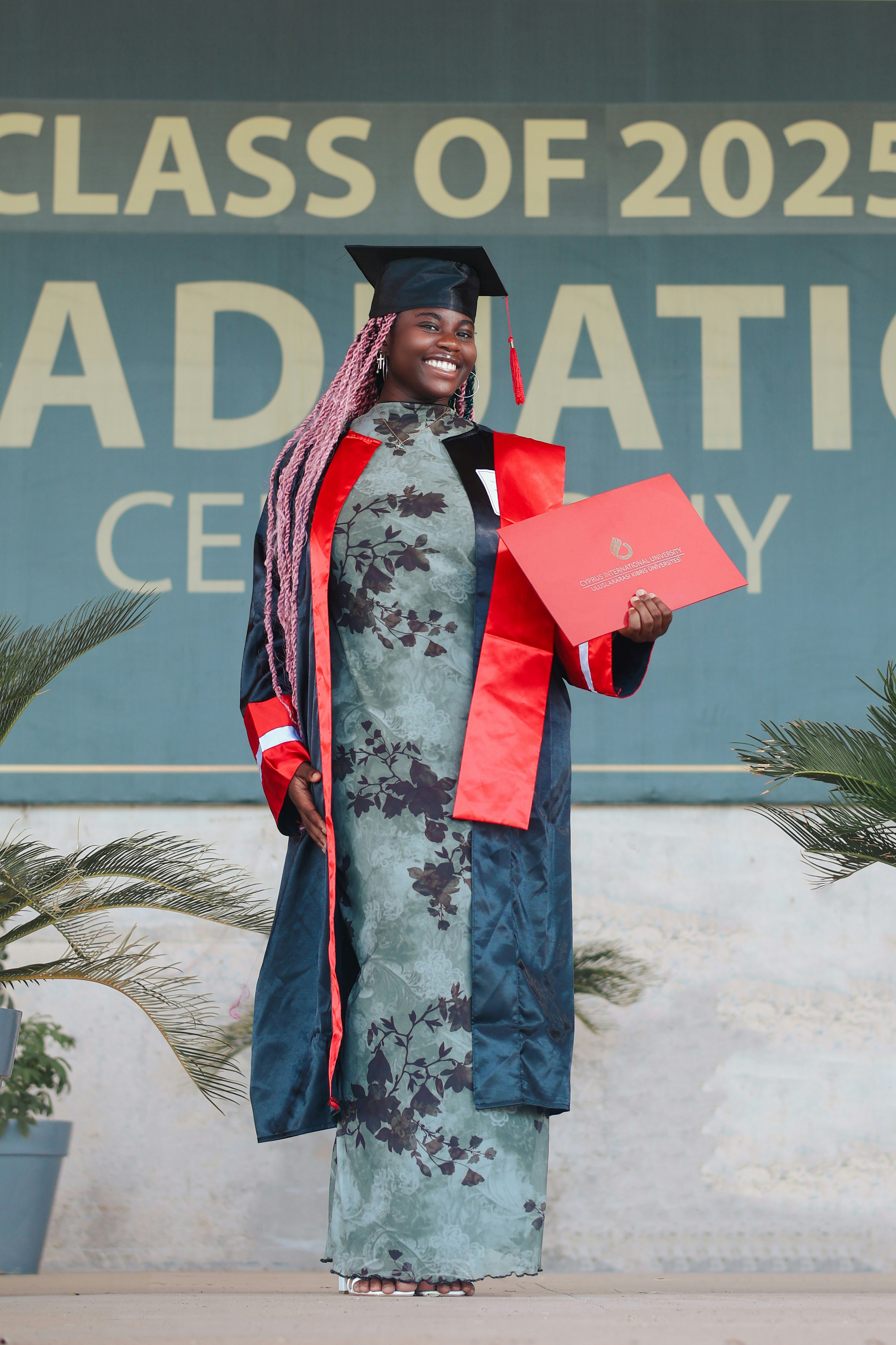 Graduate in cap and gown holding a diploma