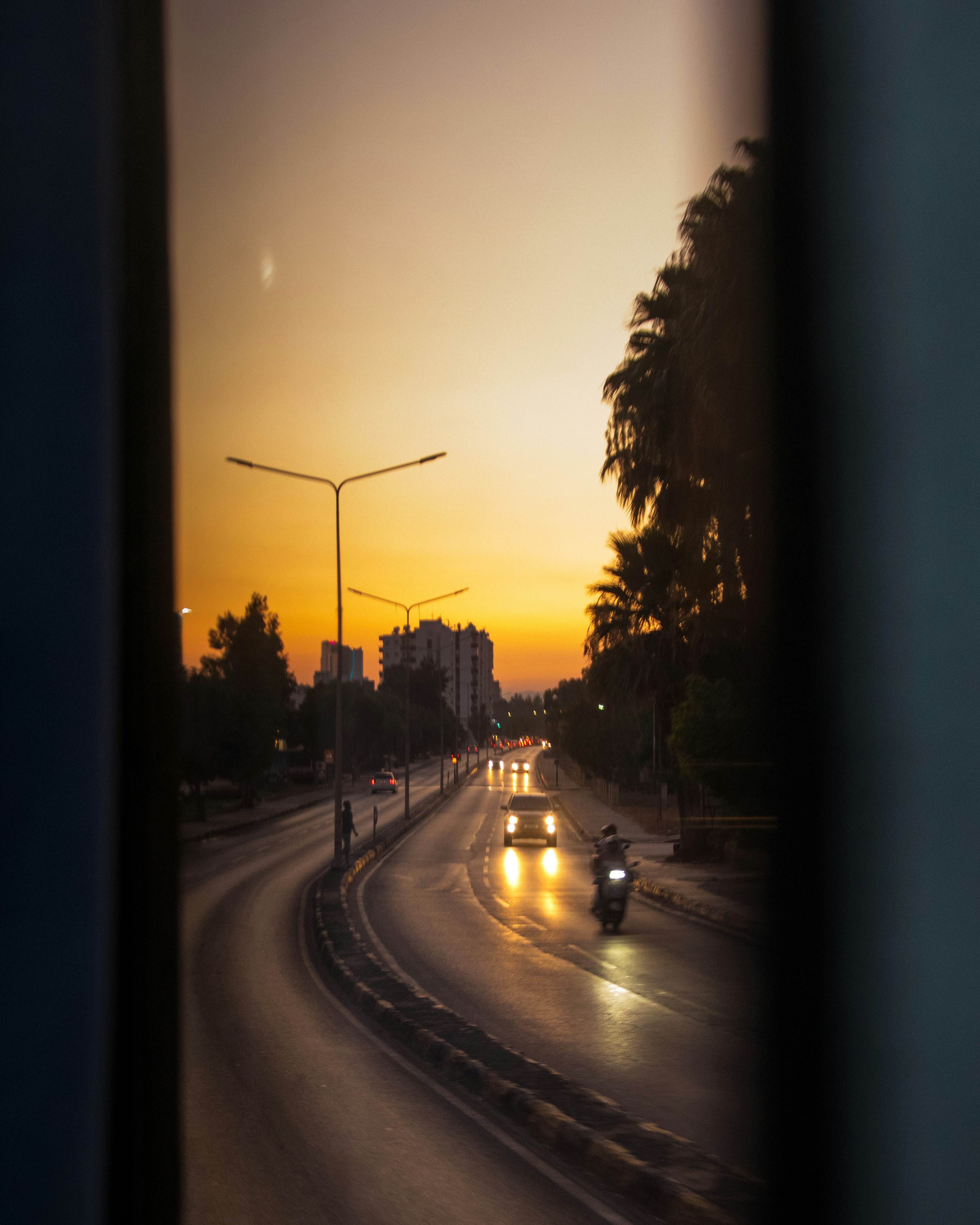 Street scene with cars and motorcycle at sunset