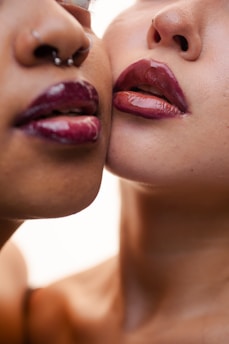 Two women's lips with glossy lipstick close-up makeup.