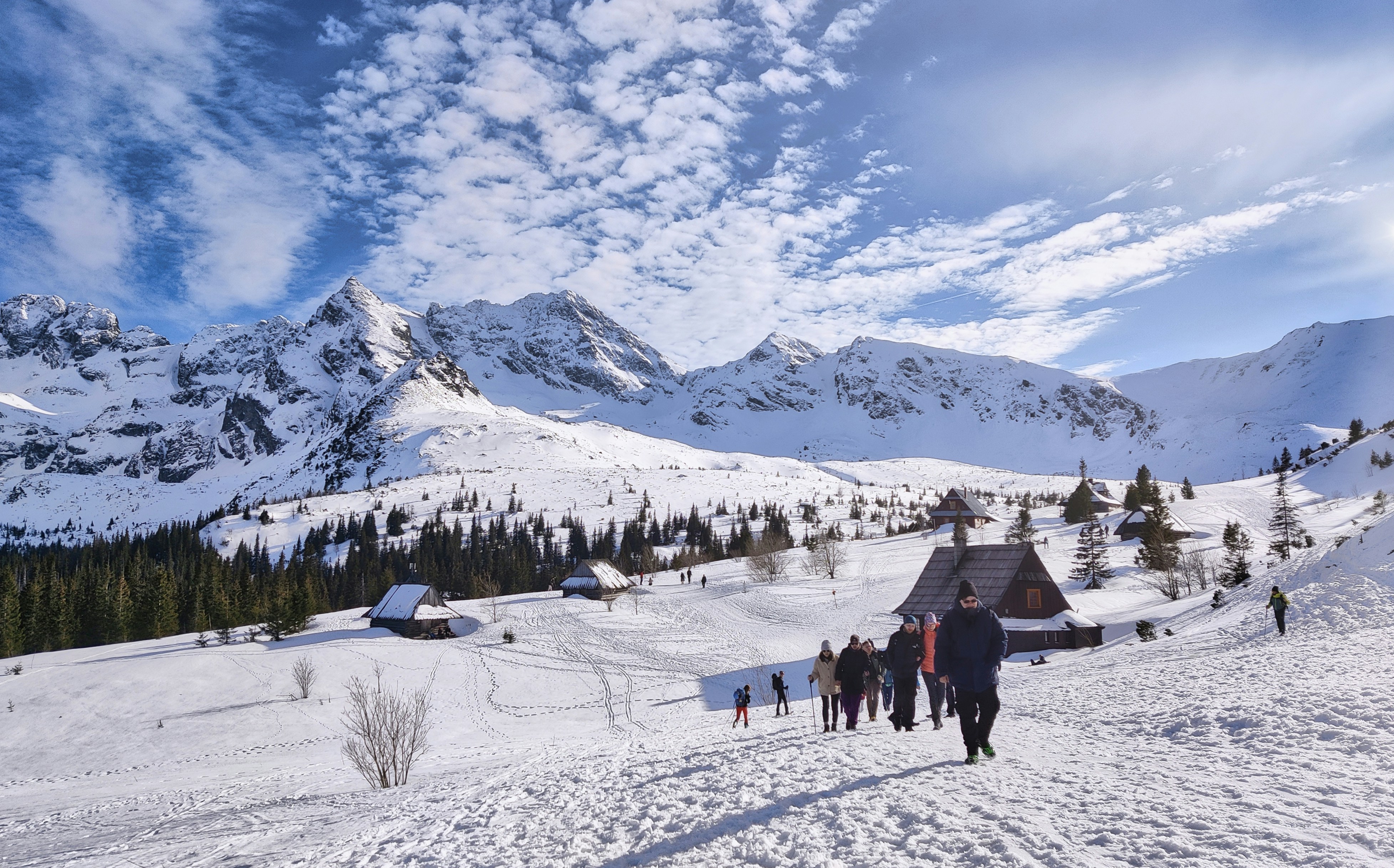 Hikers approach a mountain village in winter
