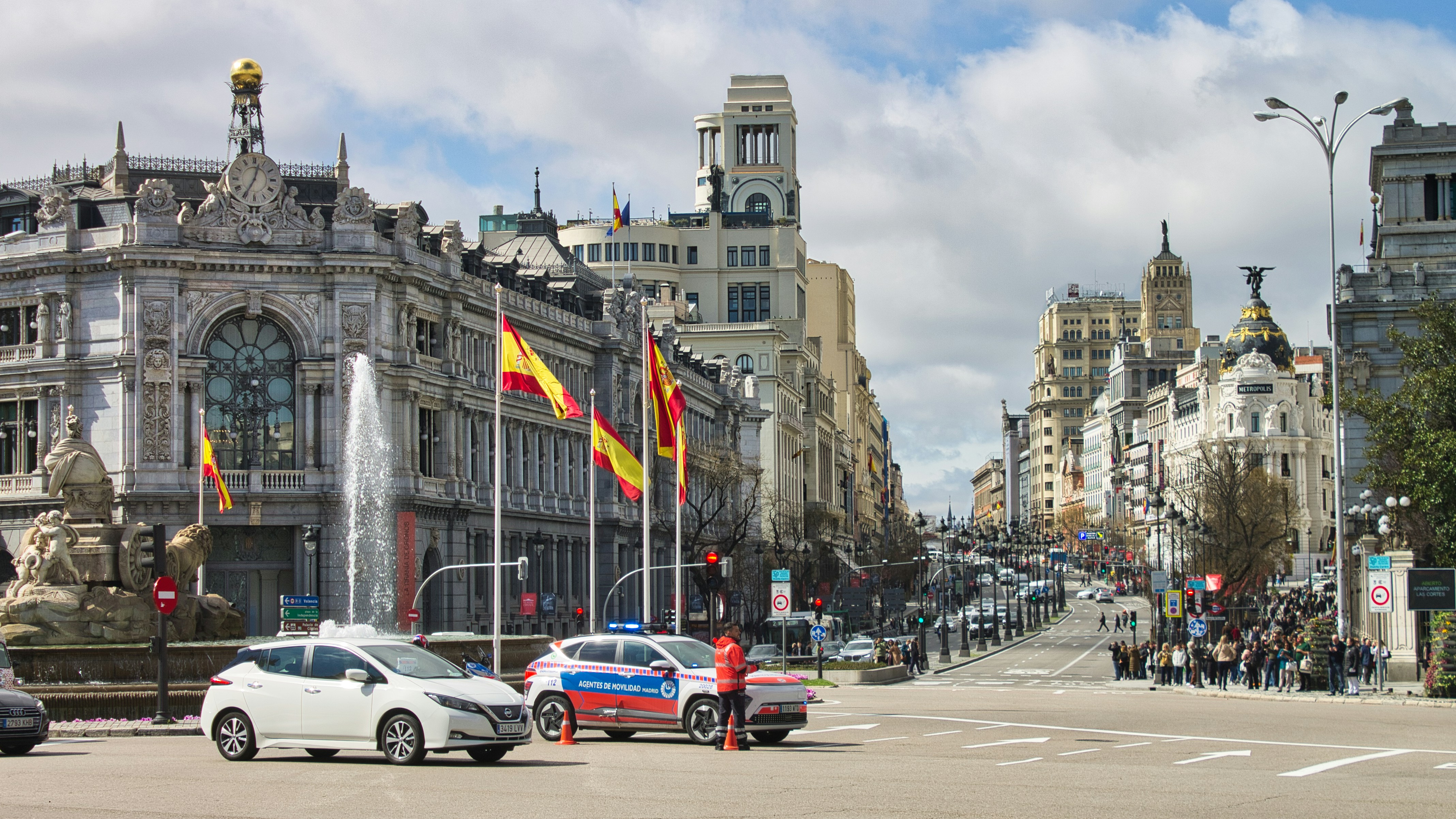 Busy street scene with spanish flags and architecture.