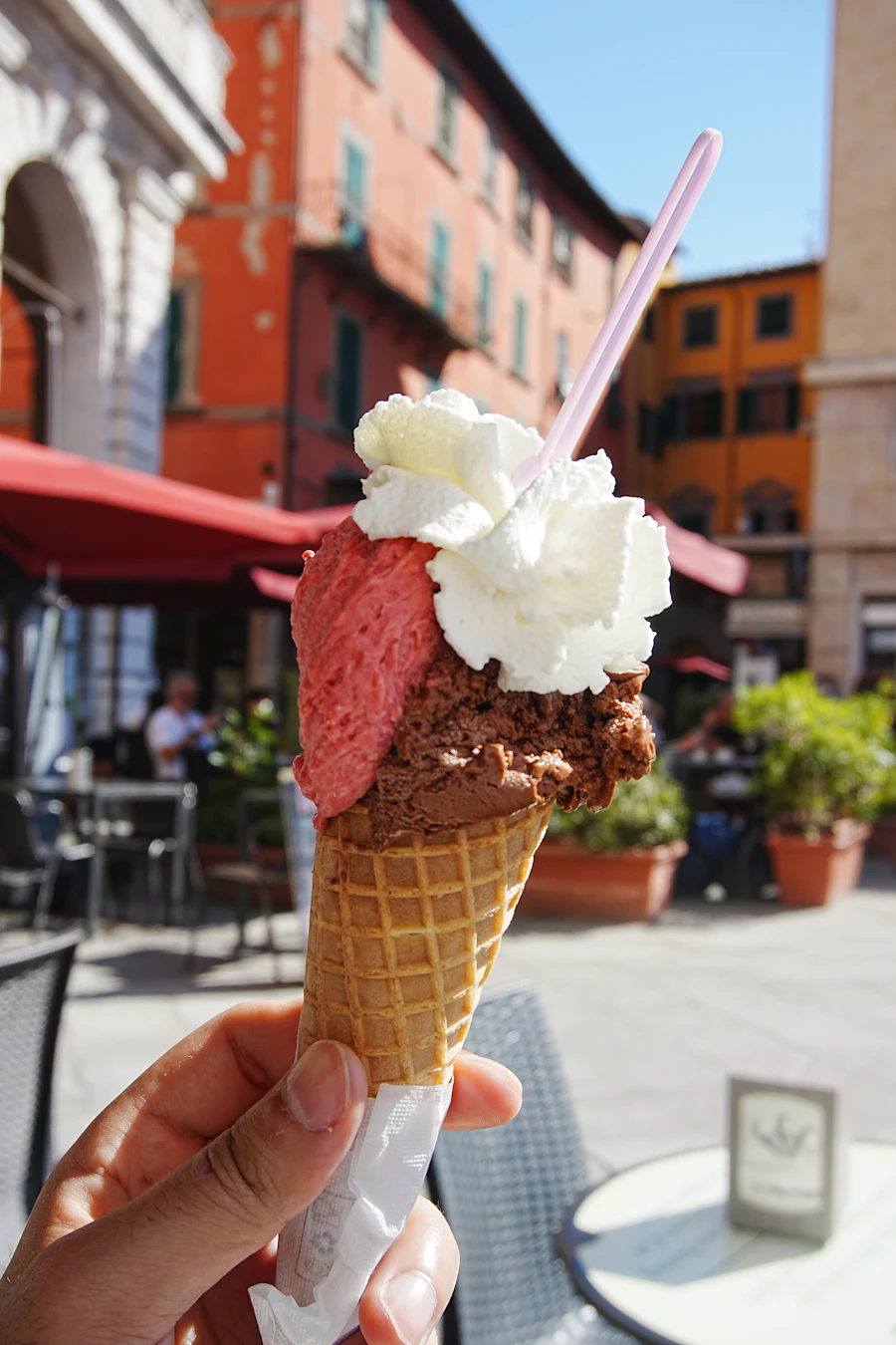 A hand holding a two scoop gelato cone