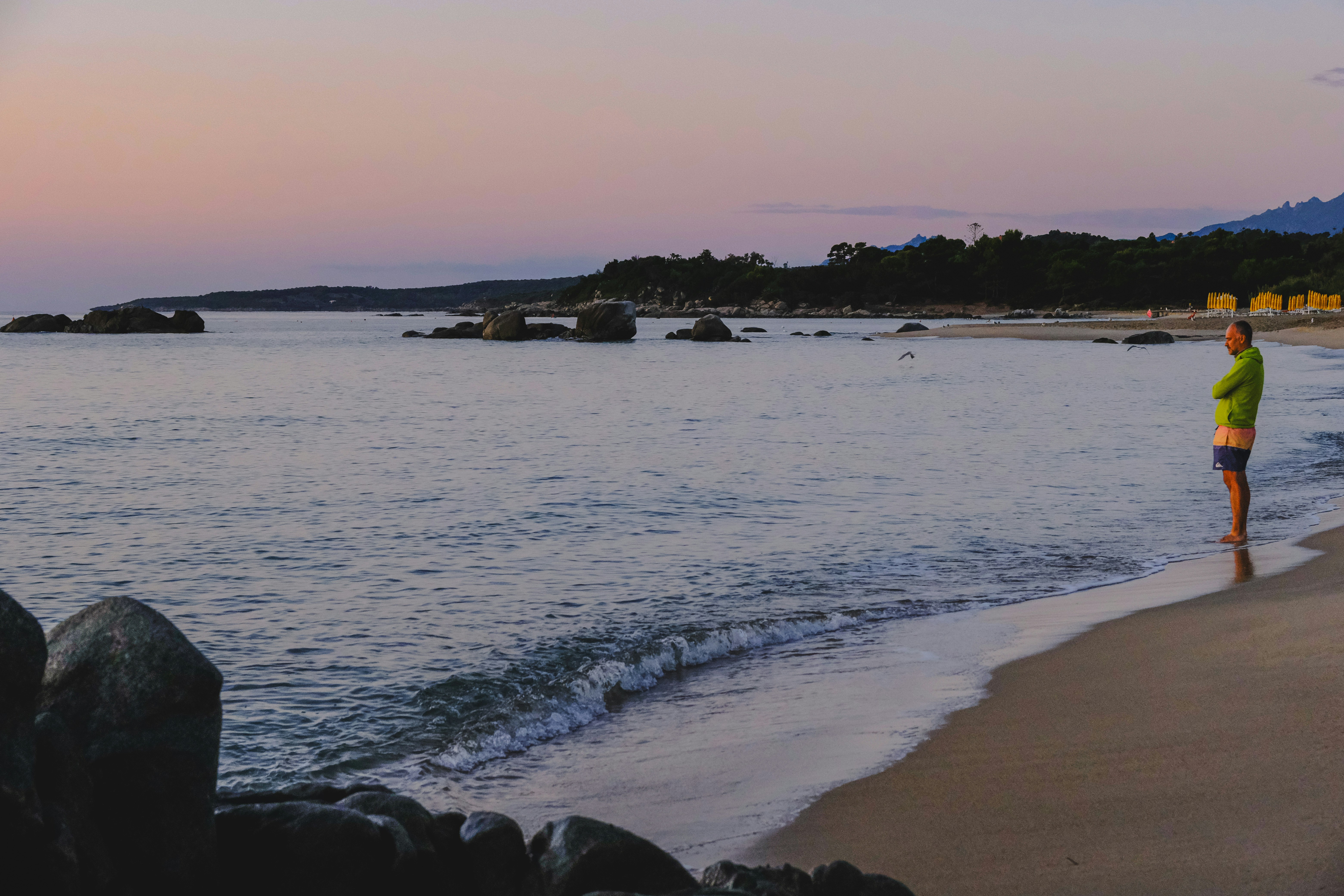 Man standing on a beach at sunset