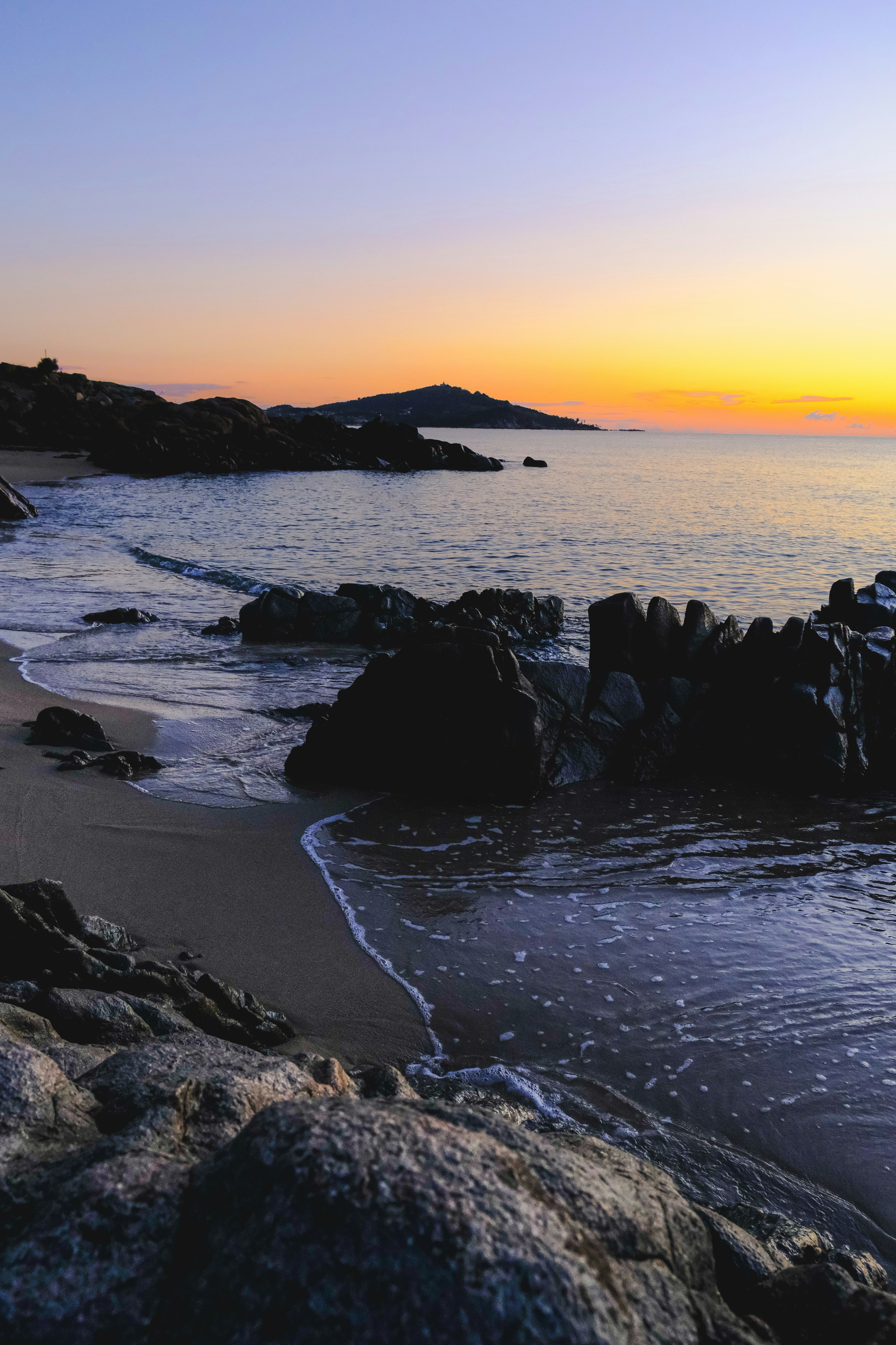 Rocky beach with gentle waves at sunrise