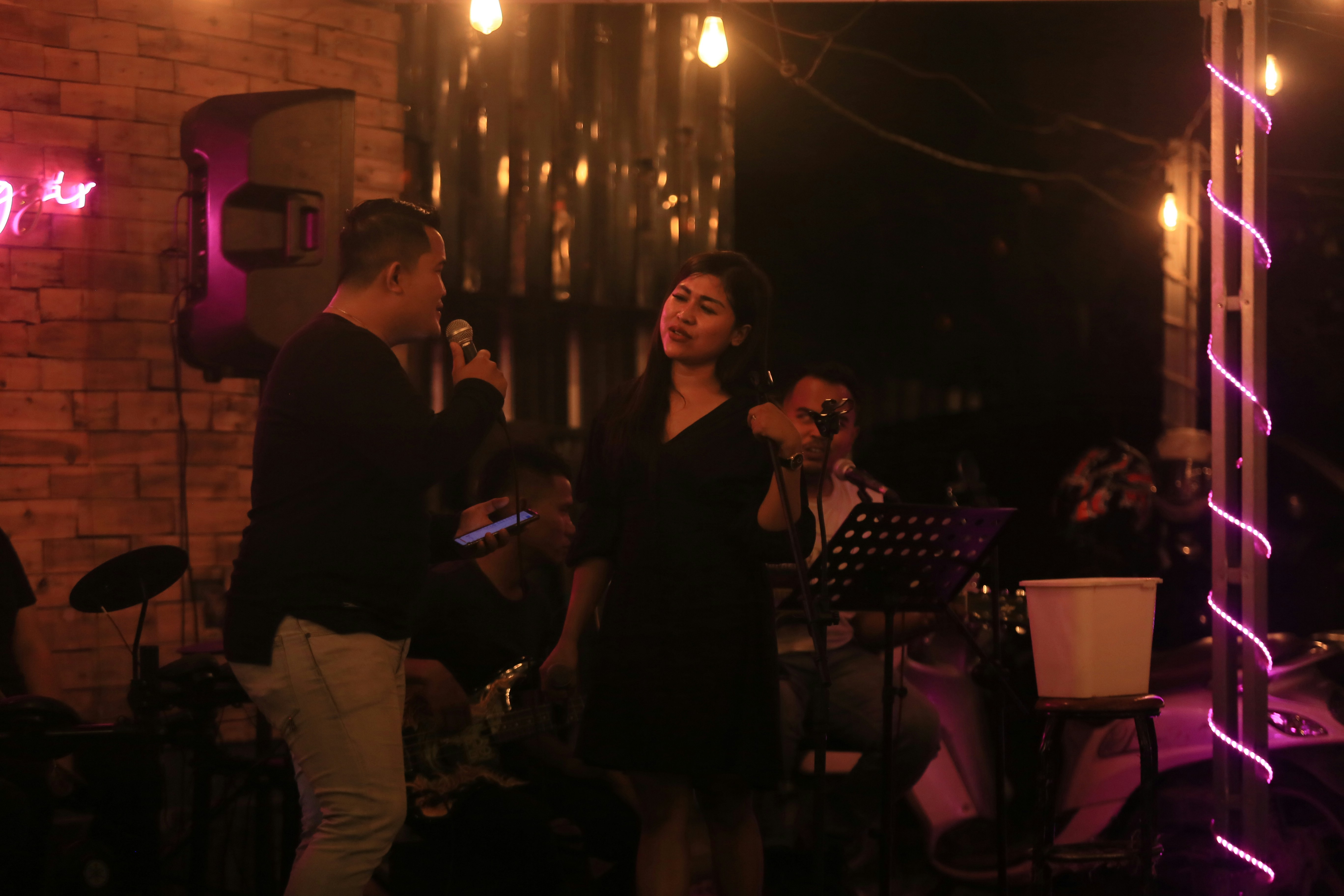 A man and woman performing live with a band on stage