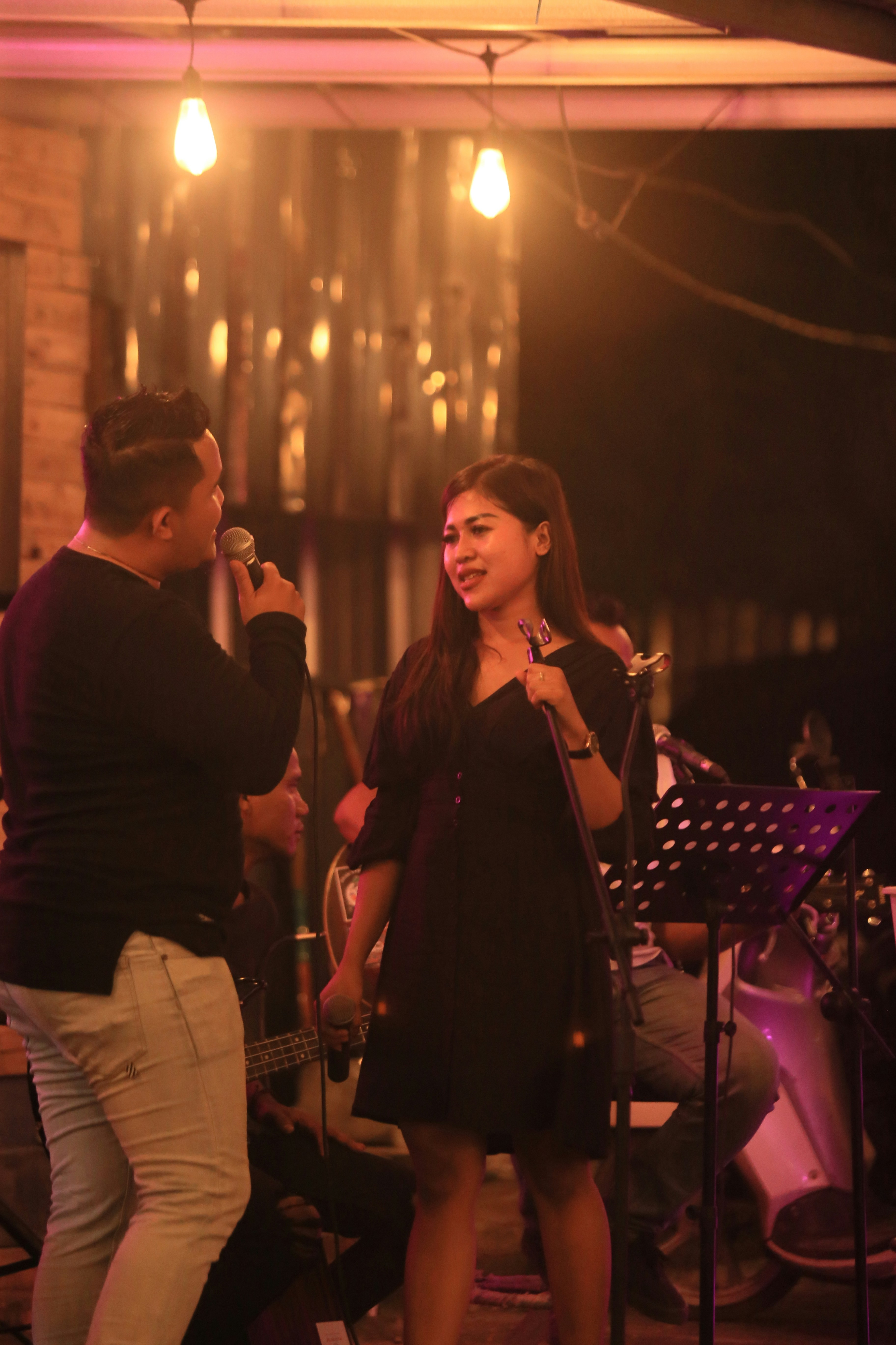 A man and woman singing on stage at a stage.