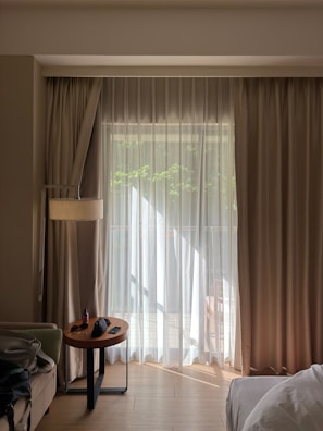 Sunlight streams through sheer curtains in a hotel room.