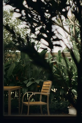 Empty chair and table in a lush garden setting.