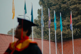 Graduation ceremony with flags and student in cap