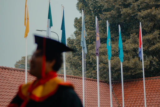 Graduation ceremony with flags and student in cap
