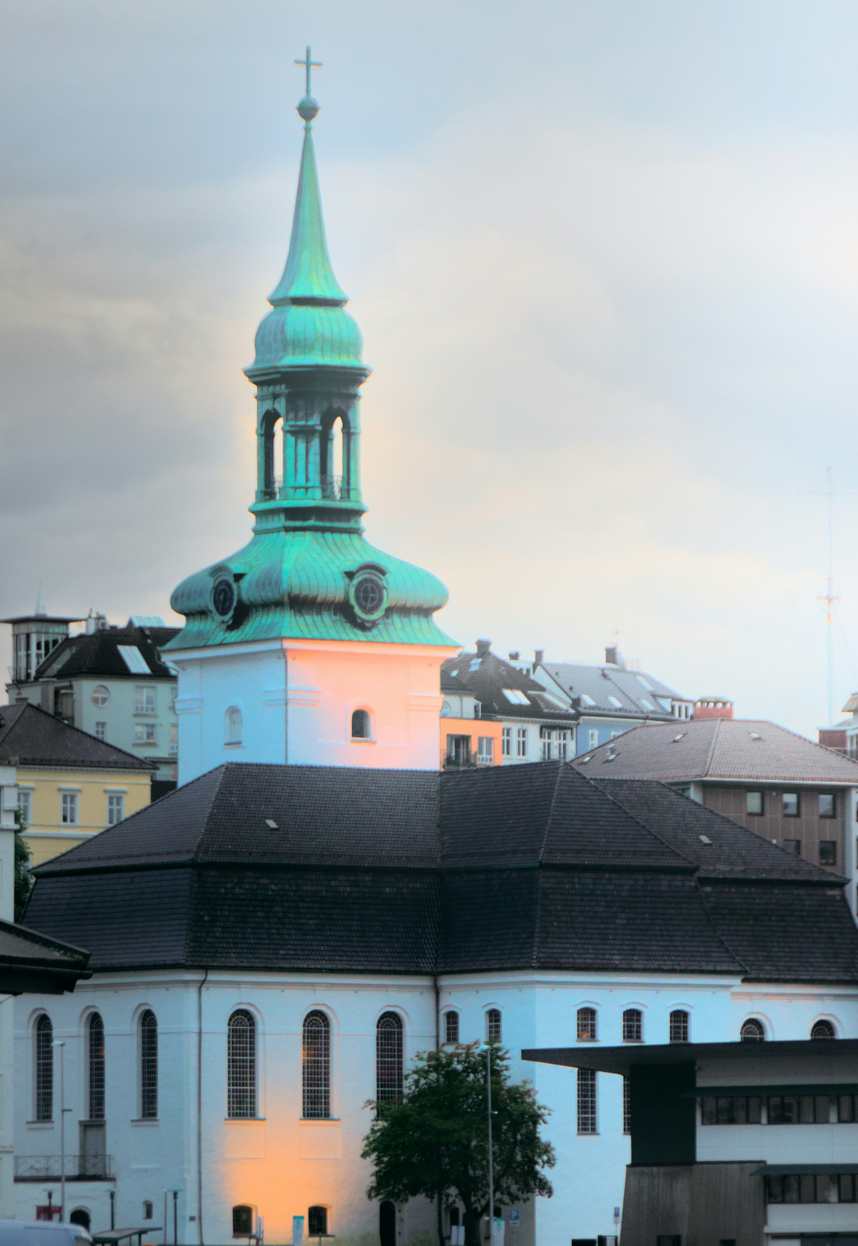 Chiesa bianca con un campanile verde al crepuscolo