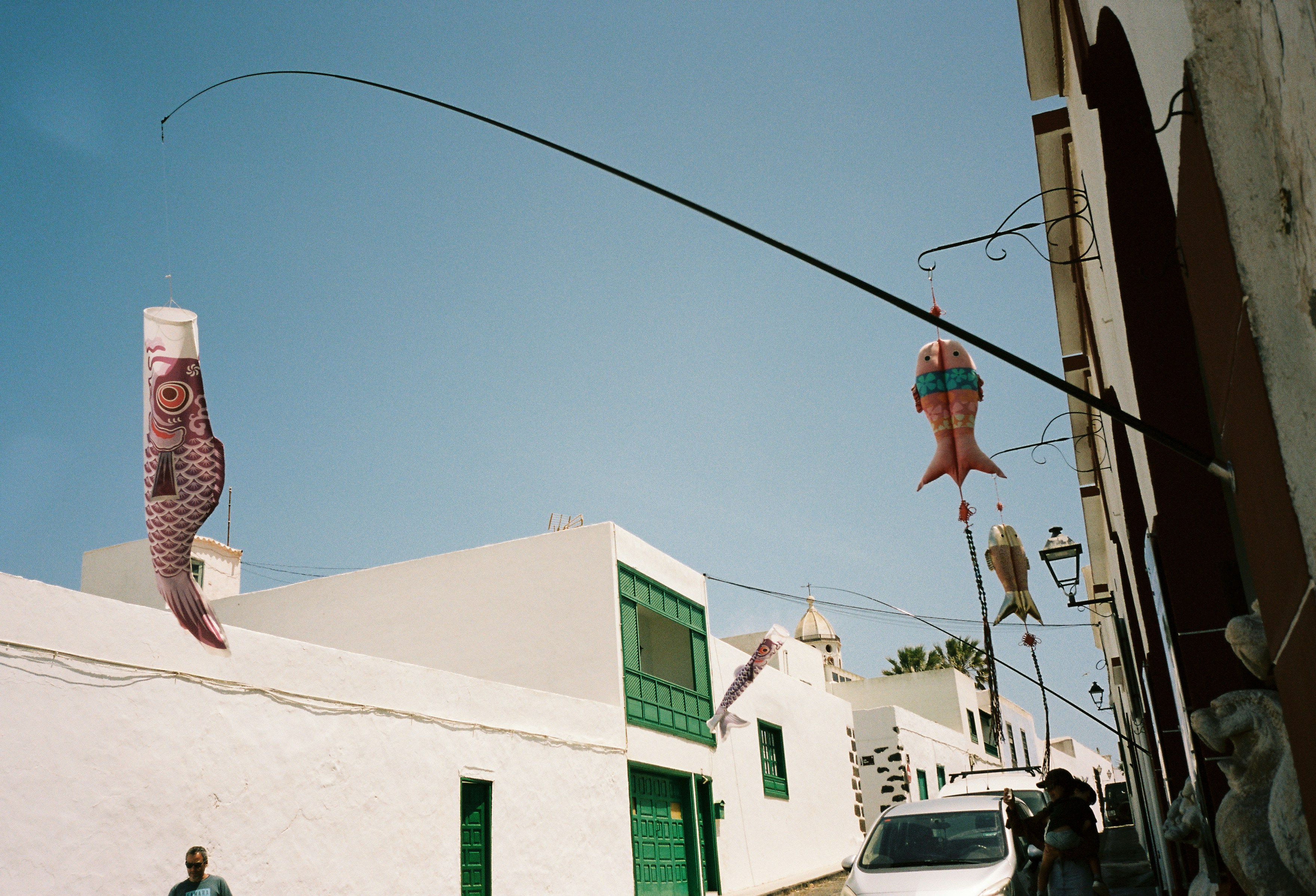 Fish kites flying over a white street
