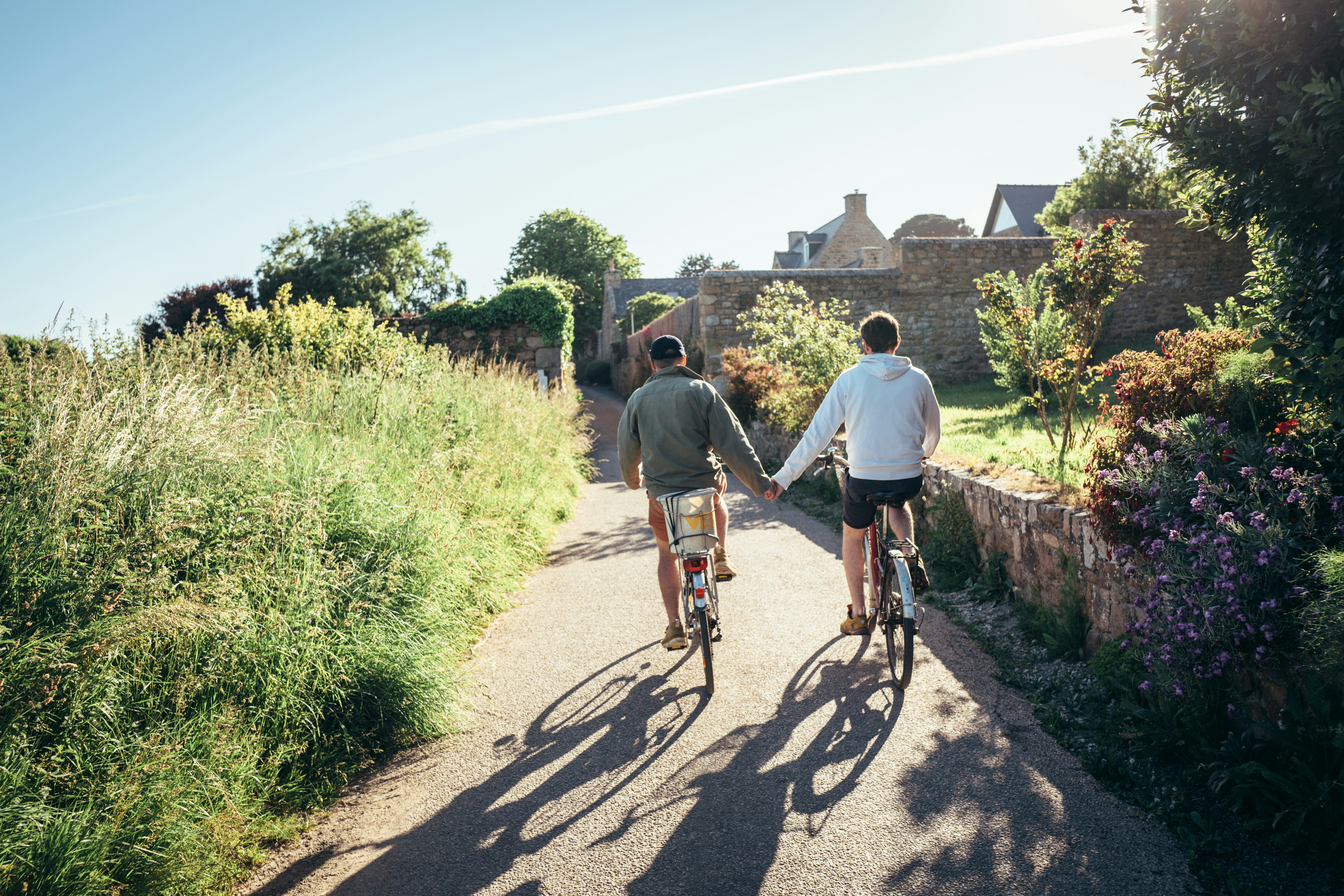 Couple holding hands while cycling on a sunny day