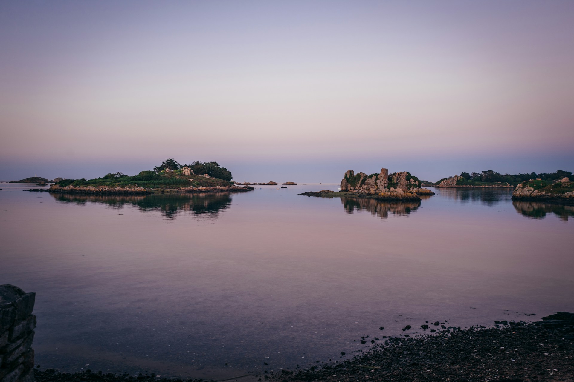 Islands in the calm ocean at twilight.
