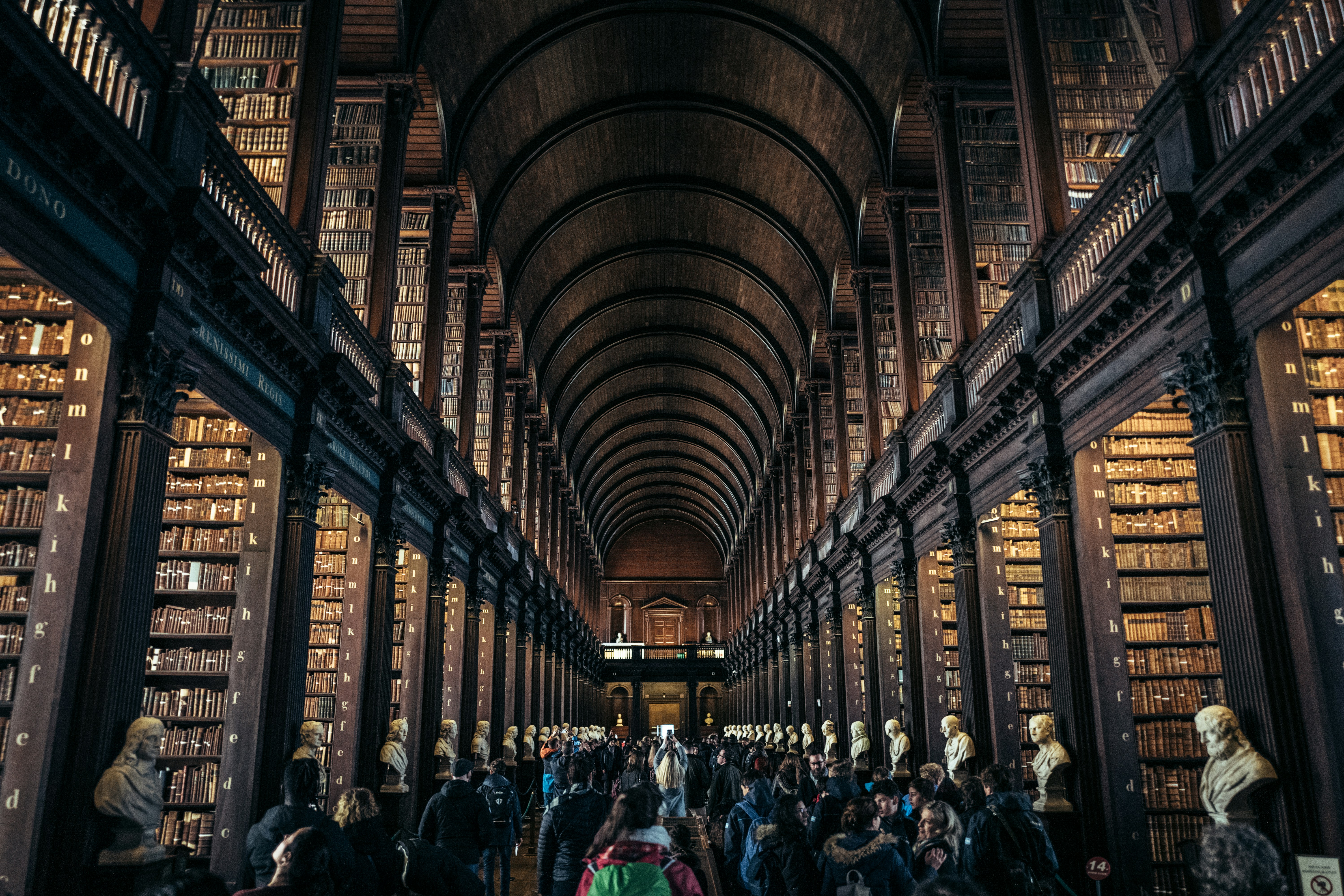 Grand library interior with towering bookshelves and people