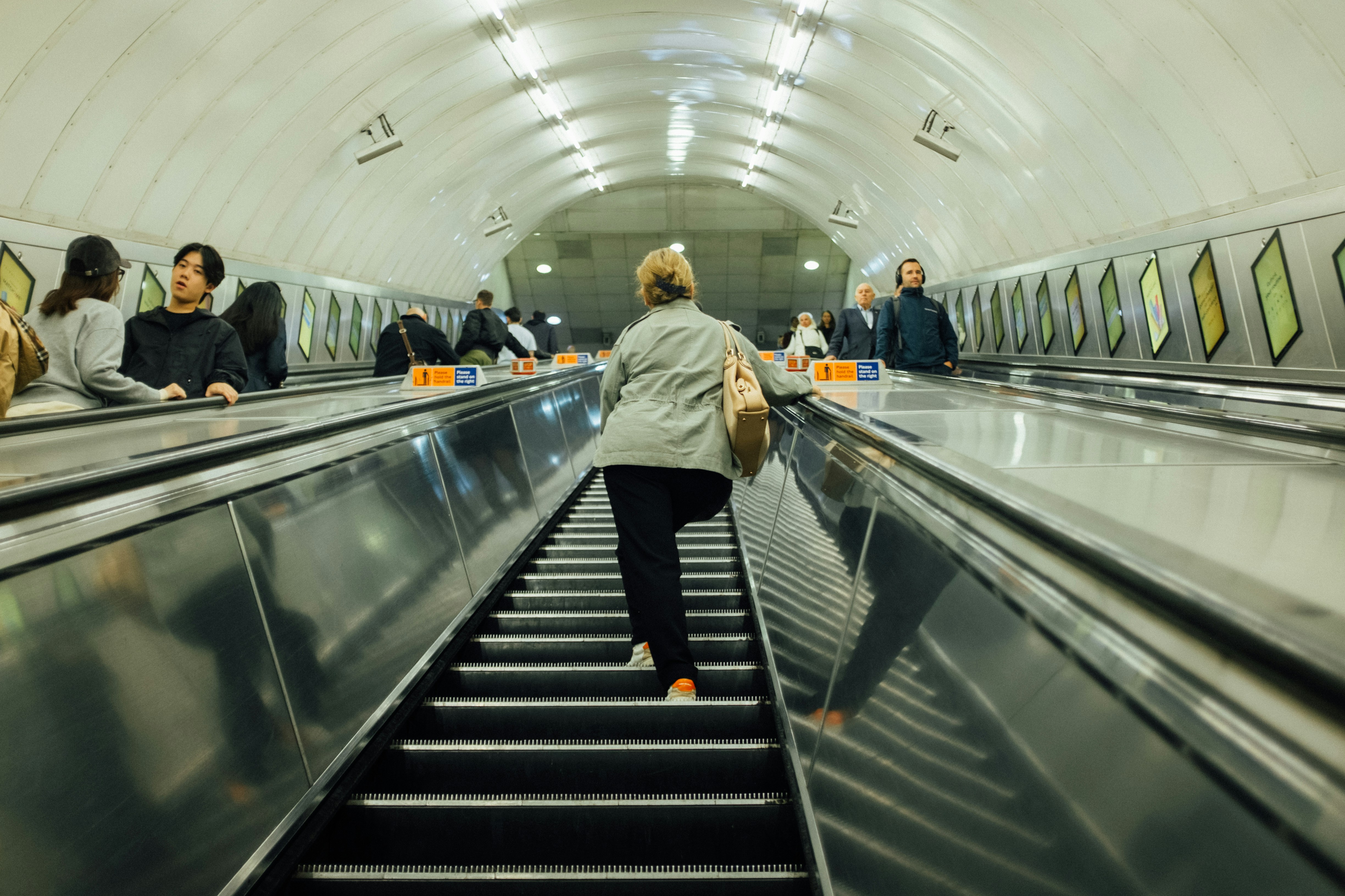 People riding escalators in a subway station