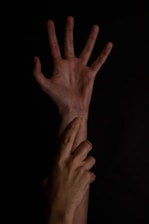 Two hands reaching out in darkness