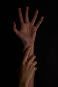 Two hands reaching out in darkness