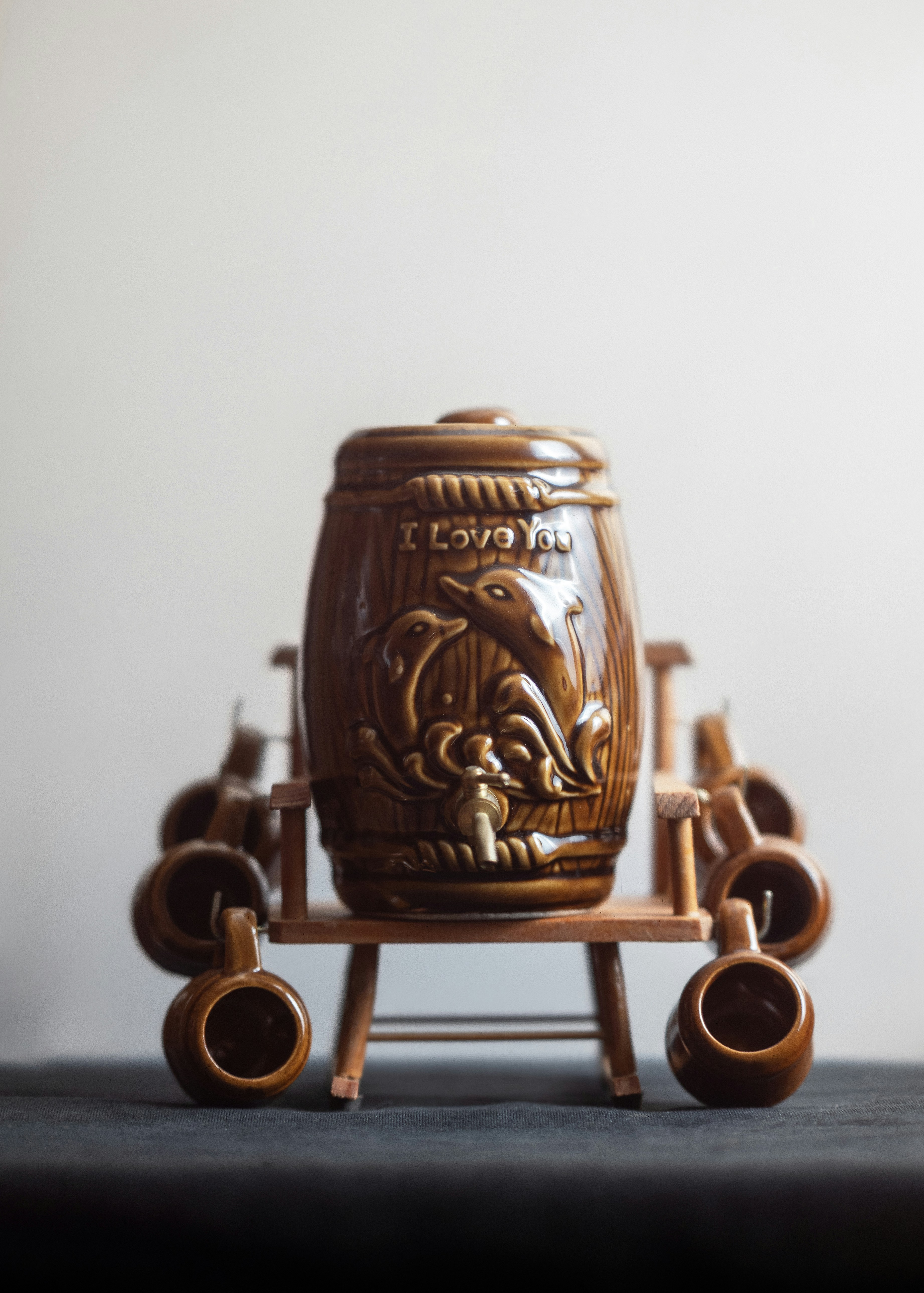 Brown ceramic barrel with dolphins and "i love you" inscription.