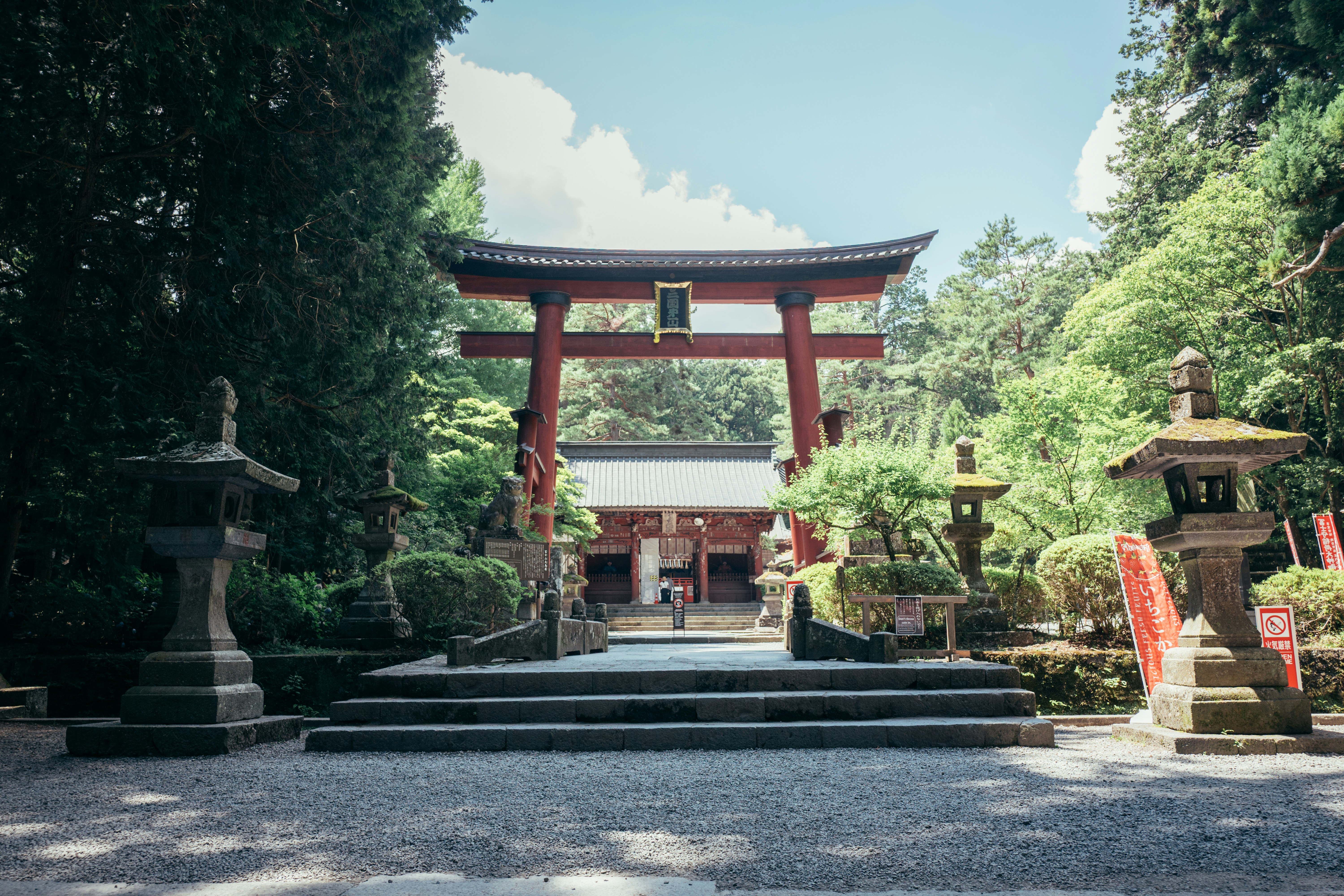 A large red torii gate at a japanese shrine.