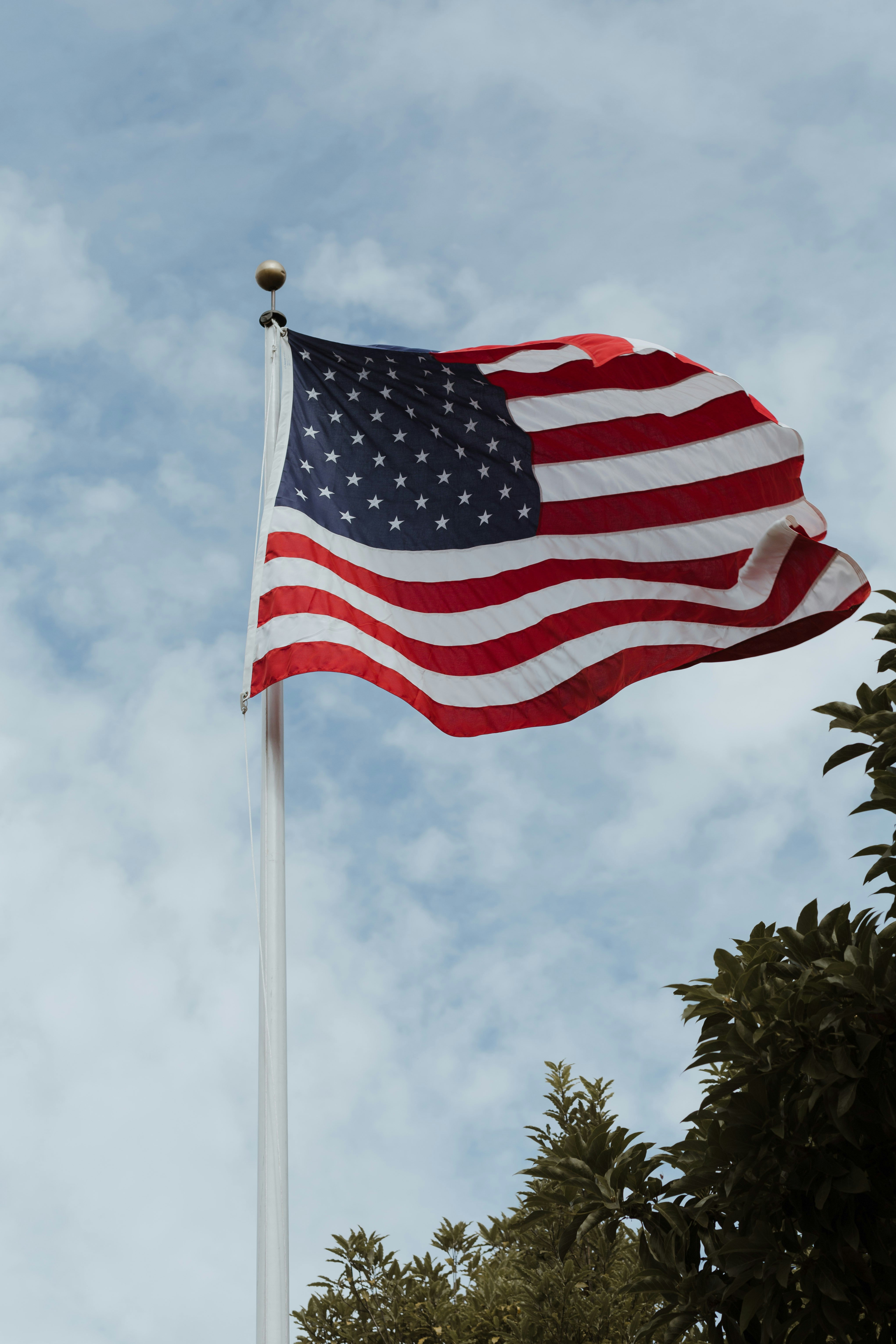 Amerikanische Flagge, die vor einem wolkenverhangenen Himmel weht.
