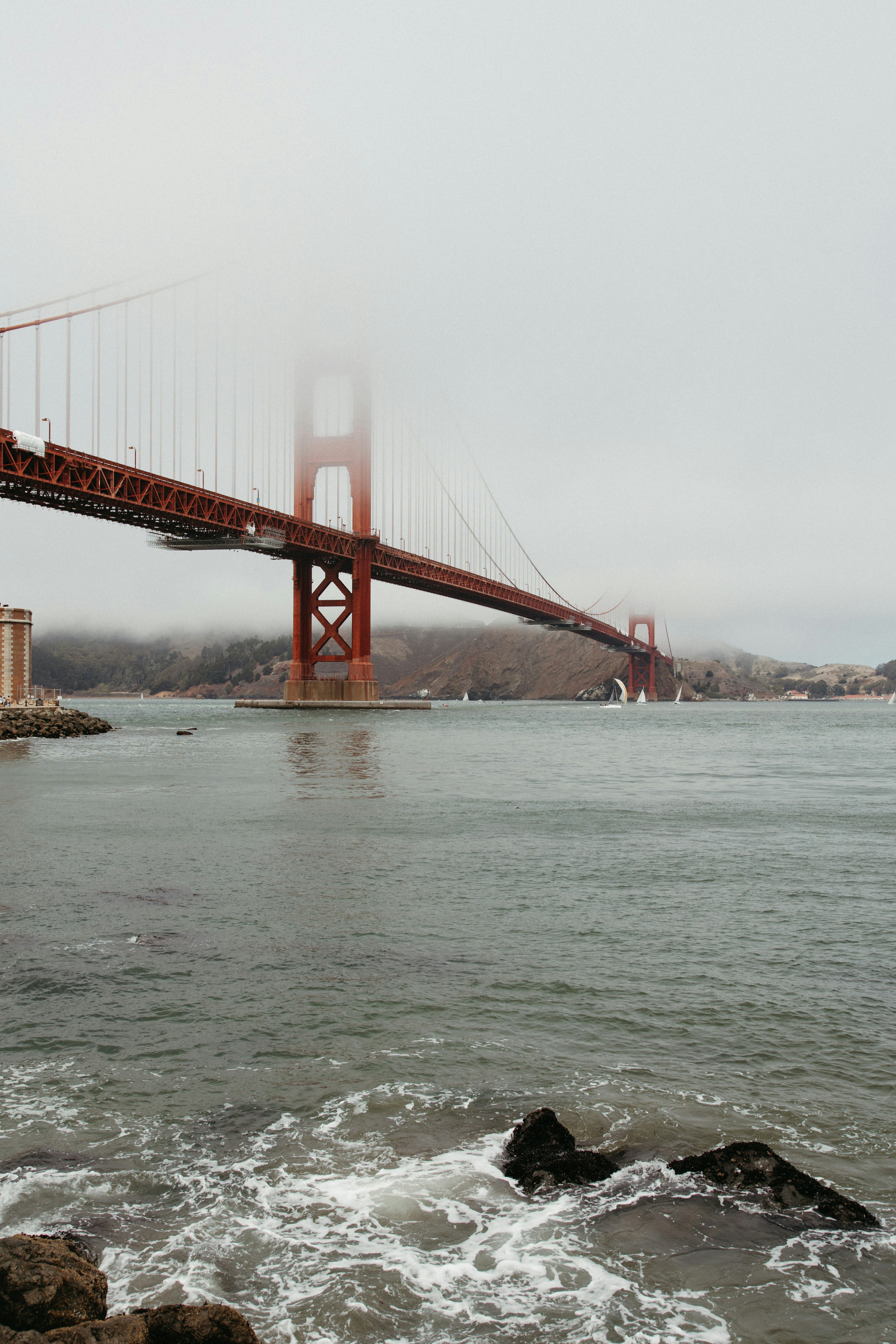 Golden gate bridge shrouded in fog over water