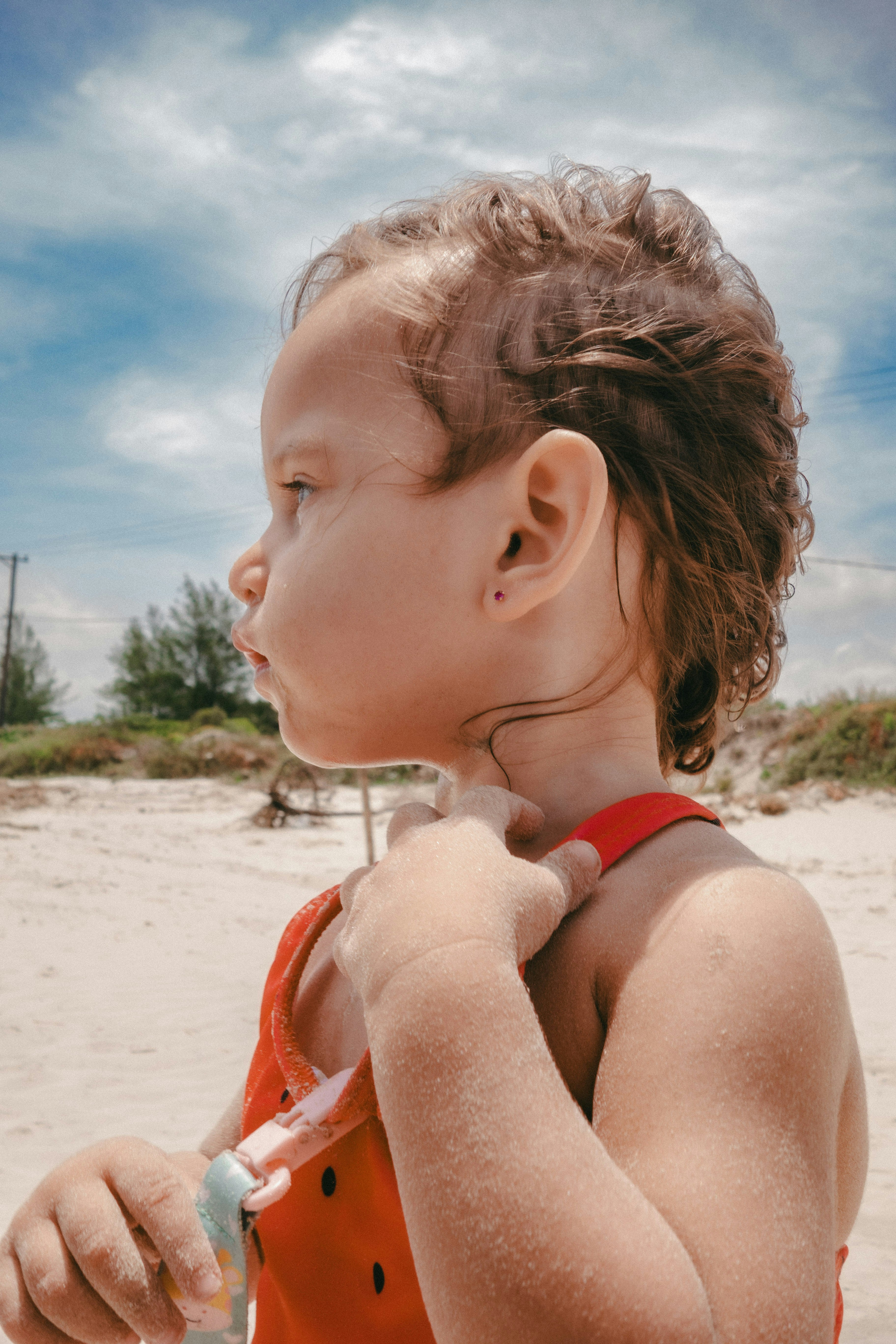 Child in red swimsuit on a sandy beach