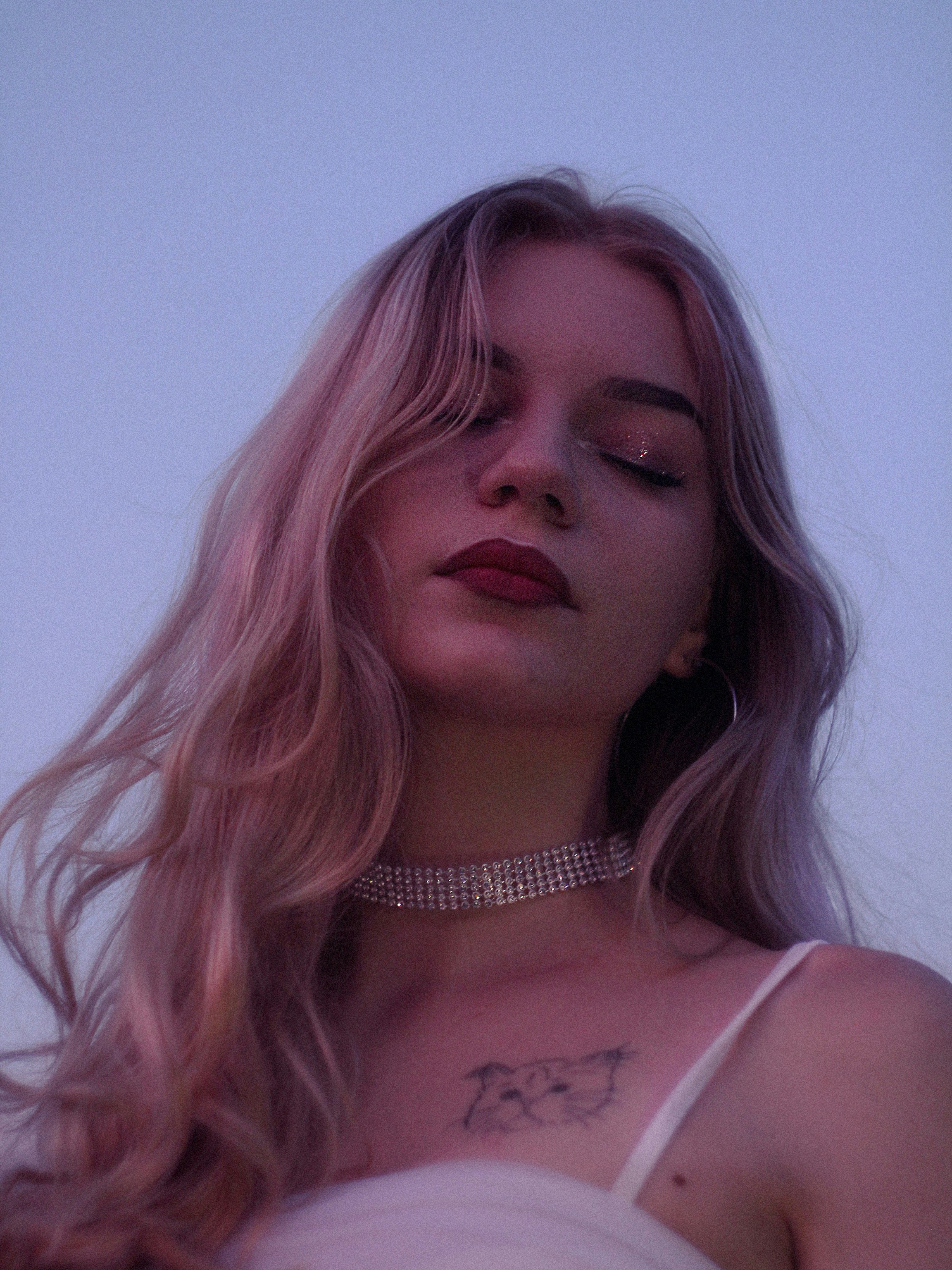 Young woman with glitter makeup and choker necklace