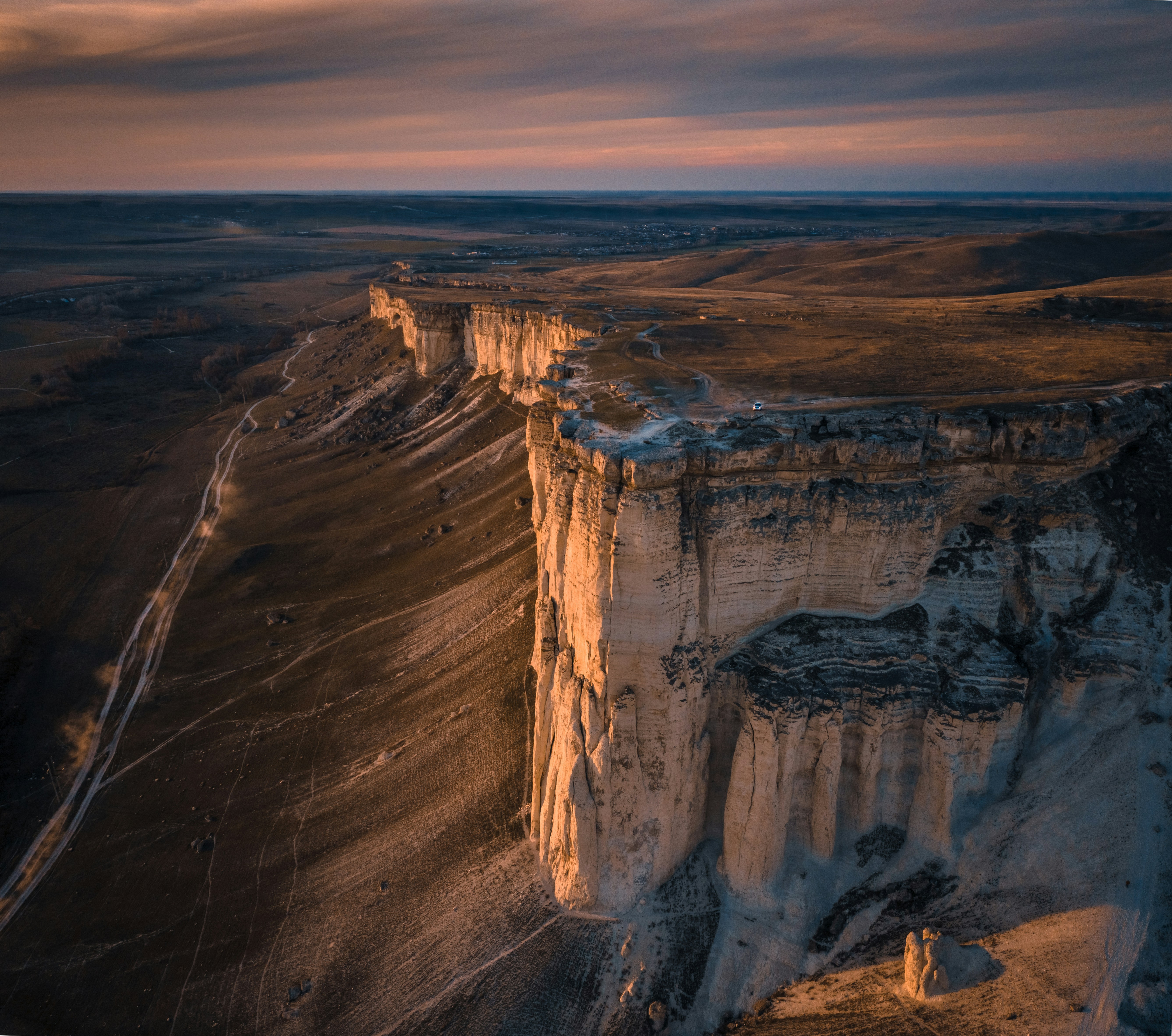 Dramatic white cliffs illuminated by golden hour sunlight.