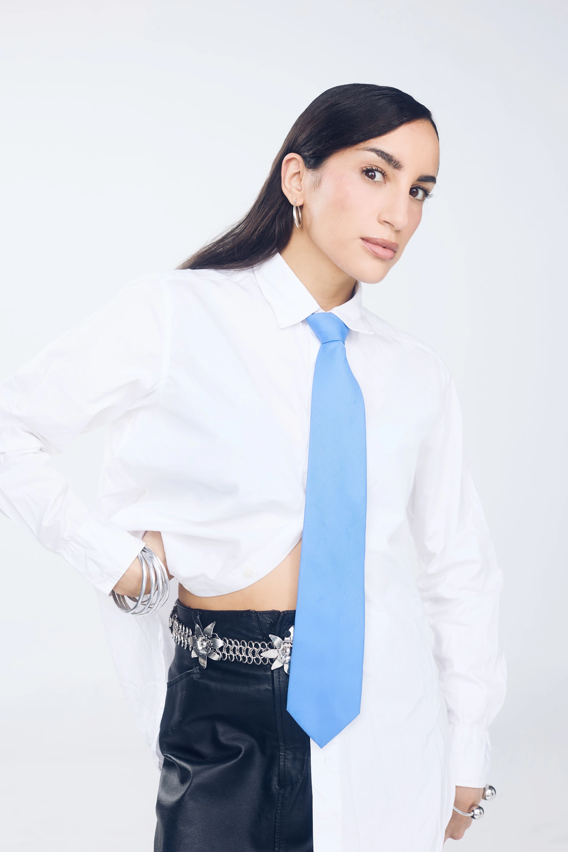 Woman in white shirt and blue tie with jewelry