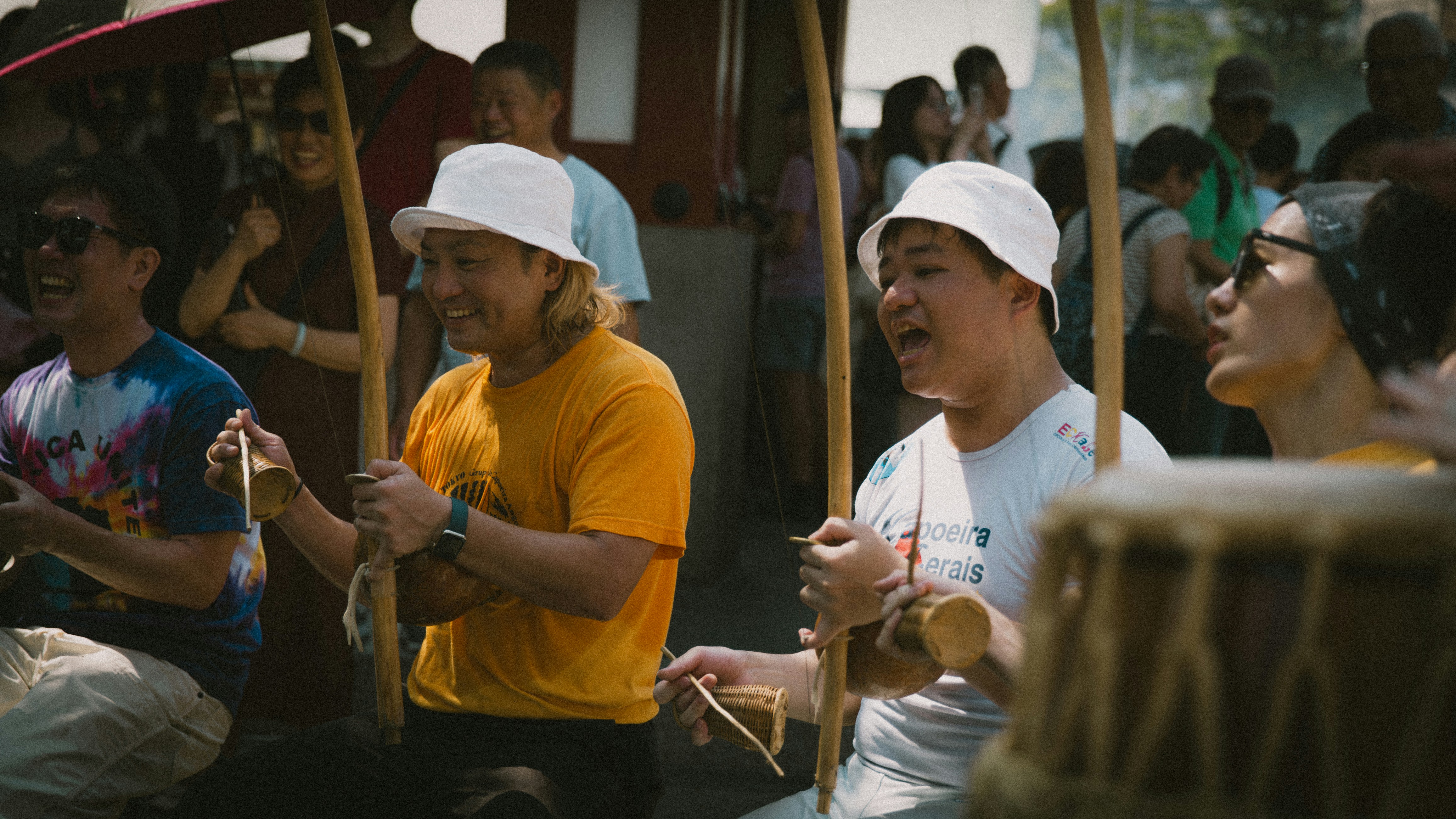 People playing drums and singing at an outdoor event
