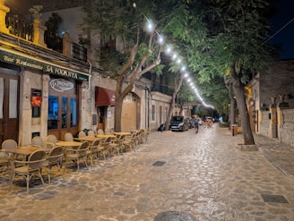Street cafe with tables and string lights at night