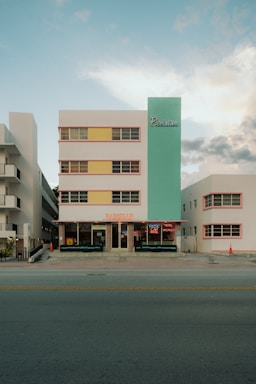 Art deco hotel with pastel colors and neon signs.