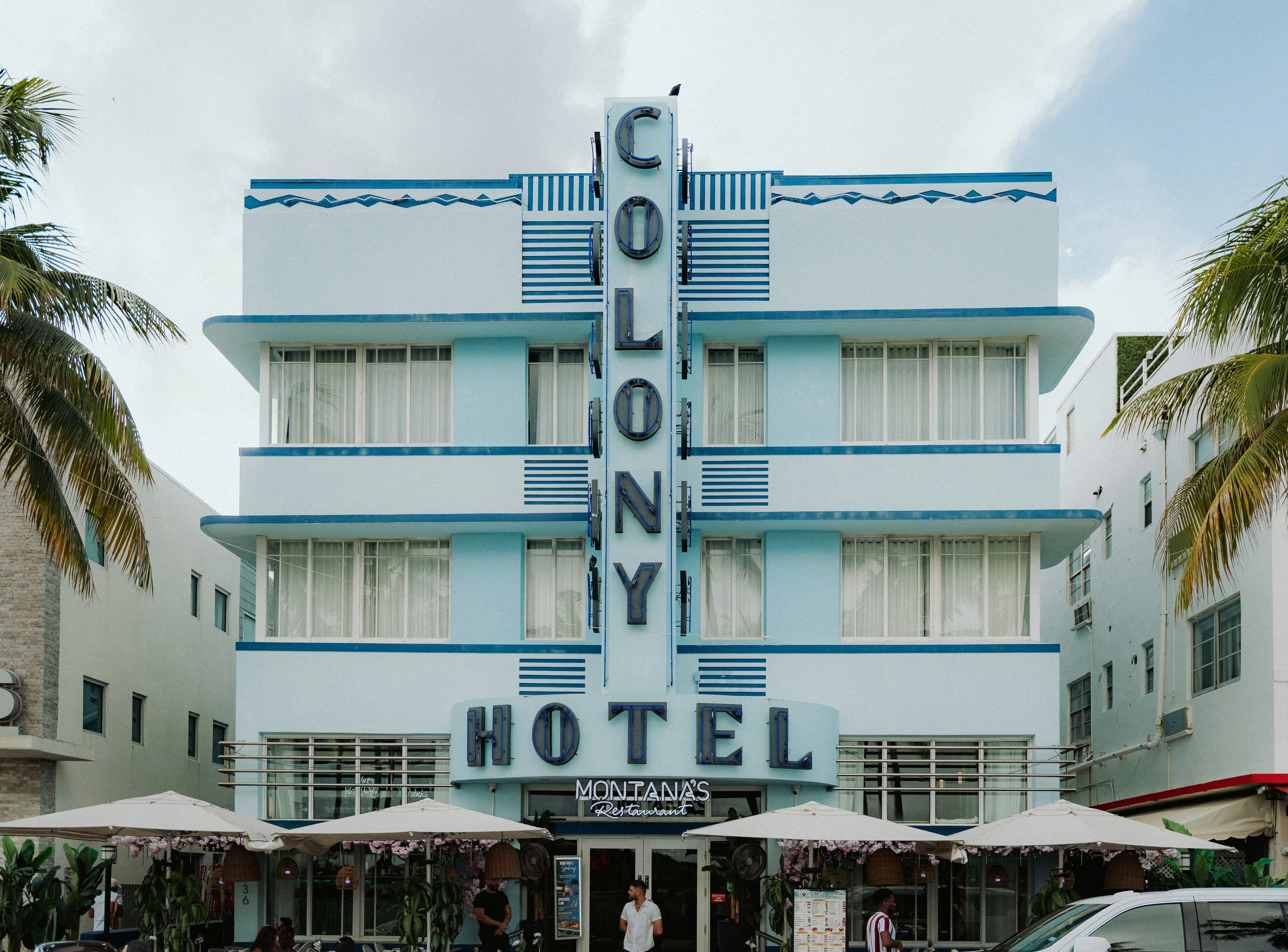 Light blue colony hotel building with art deco architecture.