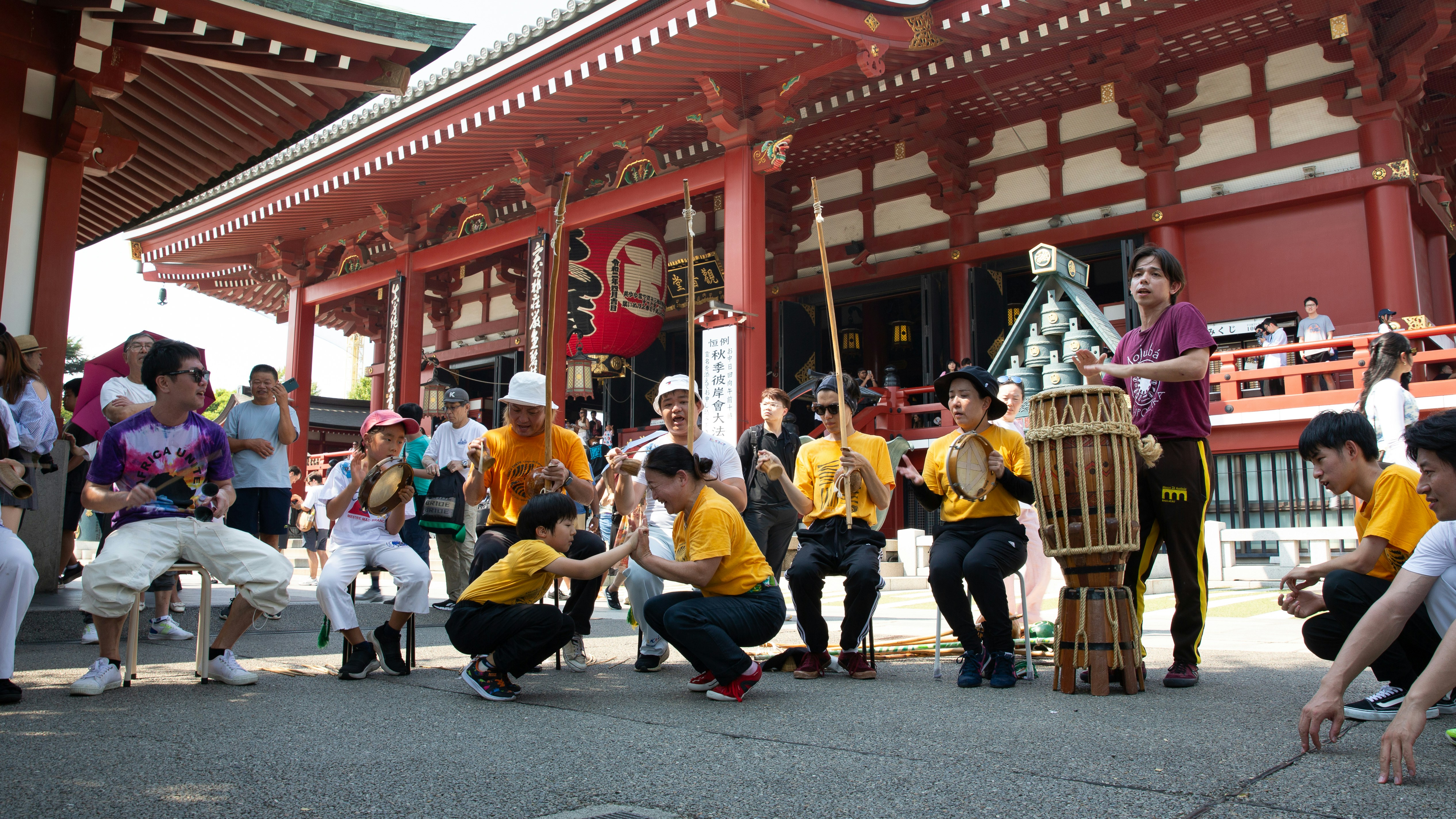 People performing a traditional japanese drum performance outdoors.