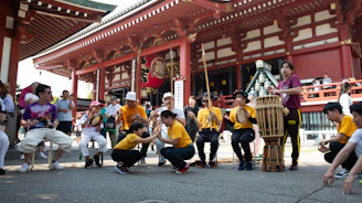People performing a traditional japanese drum performance outdoors.