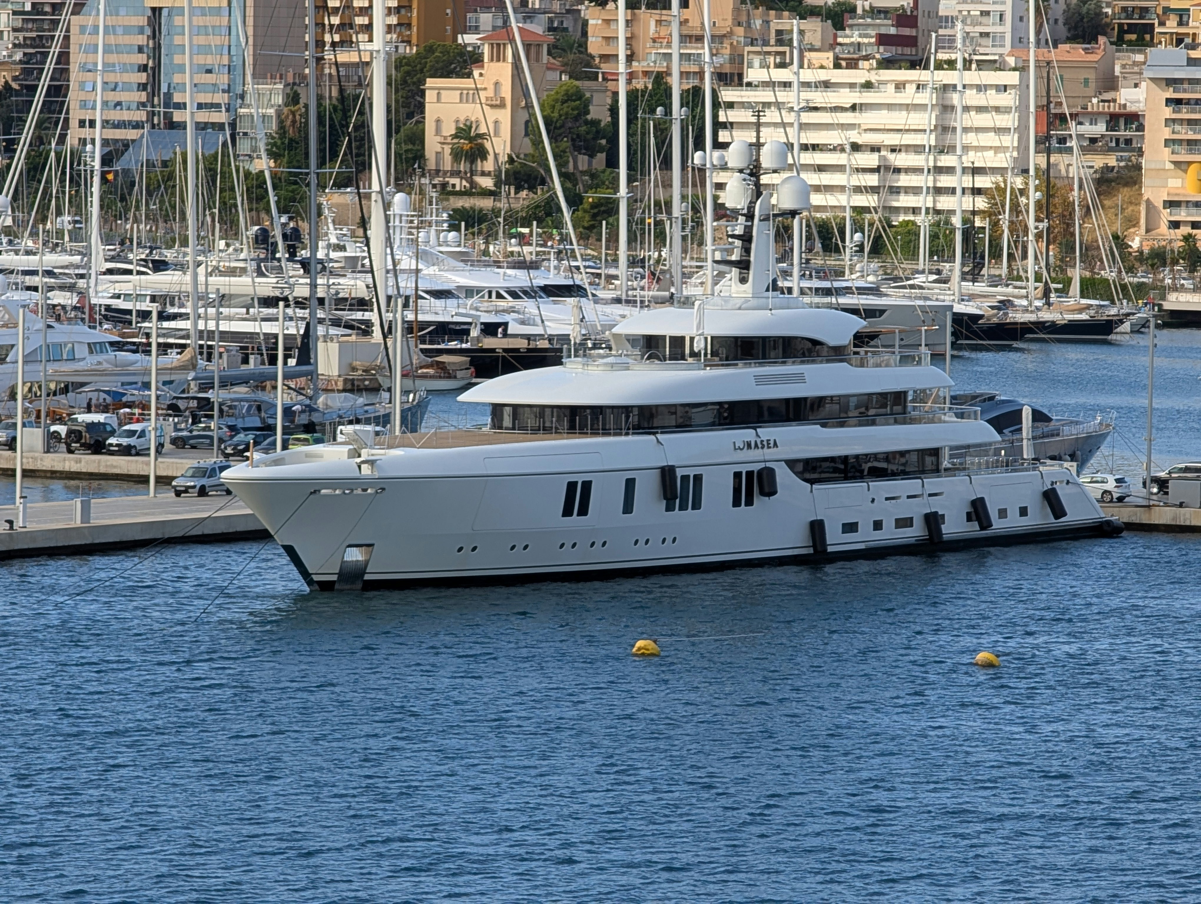 A large white yacht docked in a marina