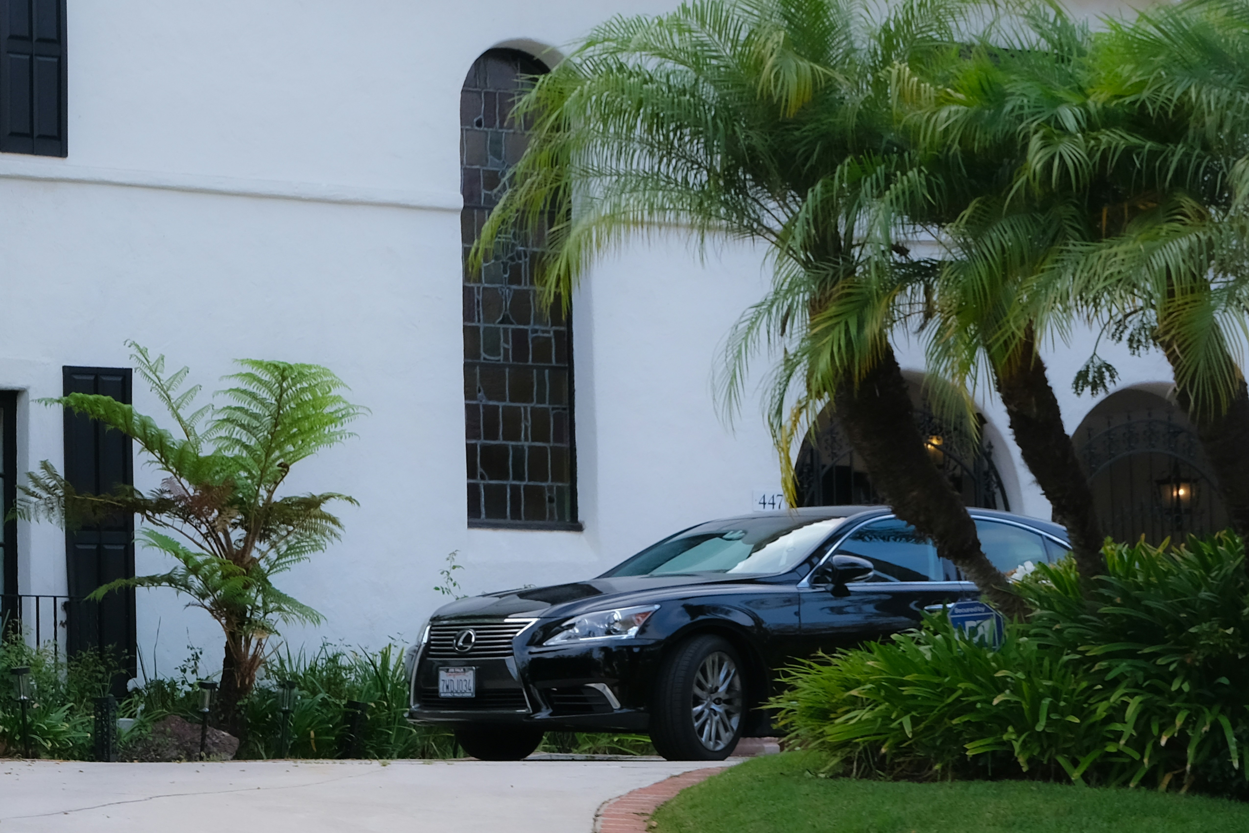 Black luxury car parked in front of white building