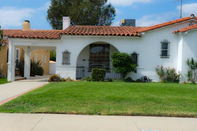 A white stucco house with a red tile roof.